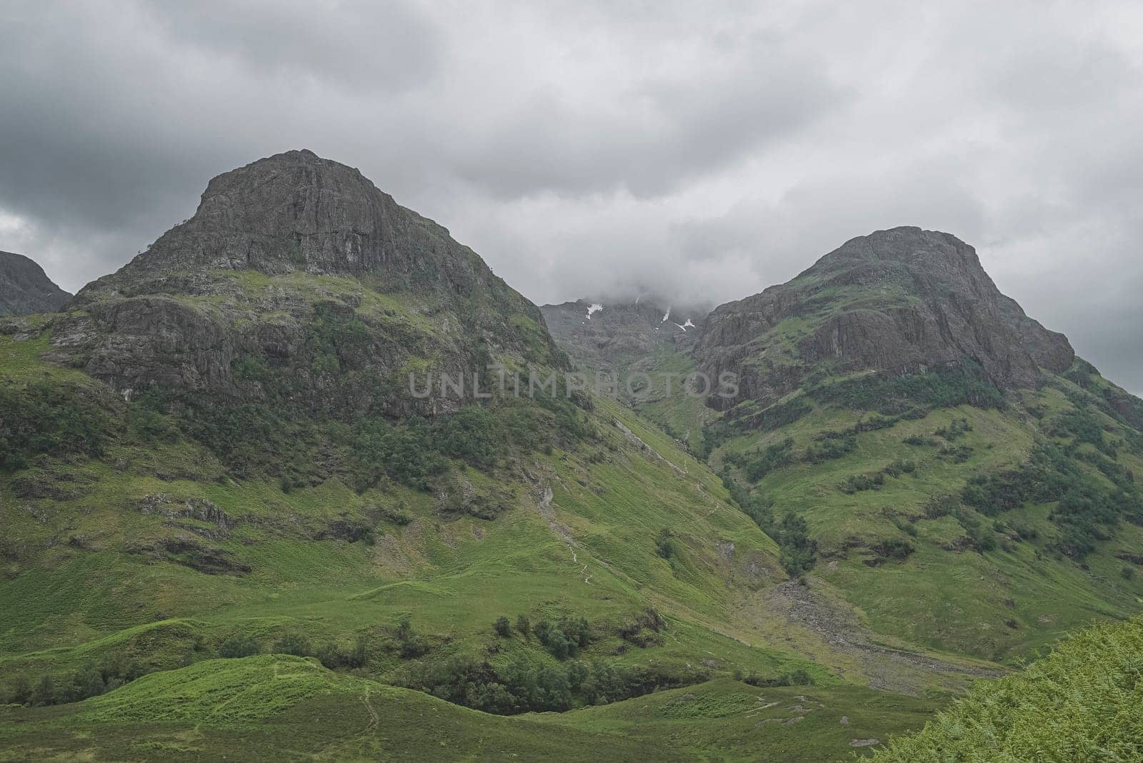 Landscape of nature in Scotland, three mountains with fog at top and no people