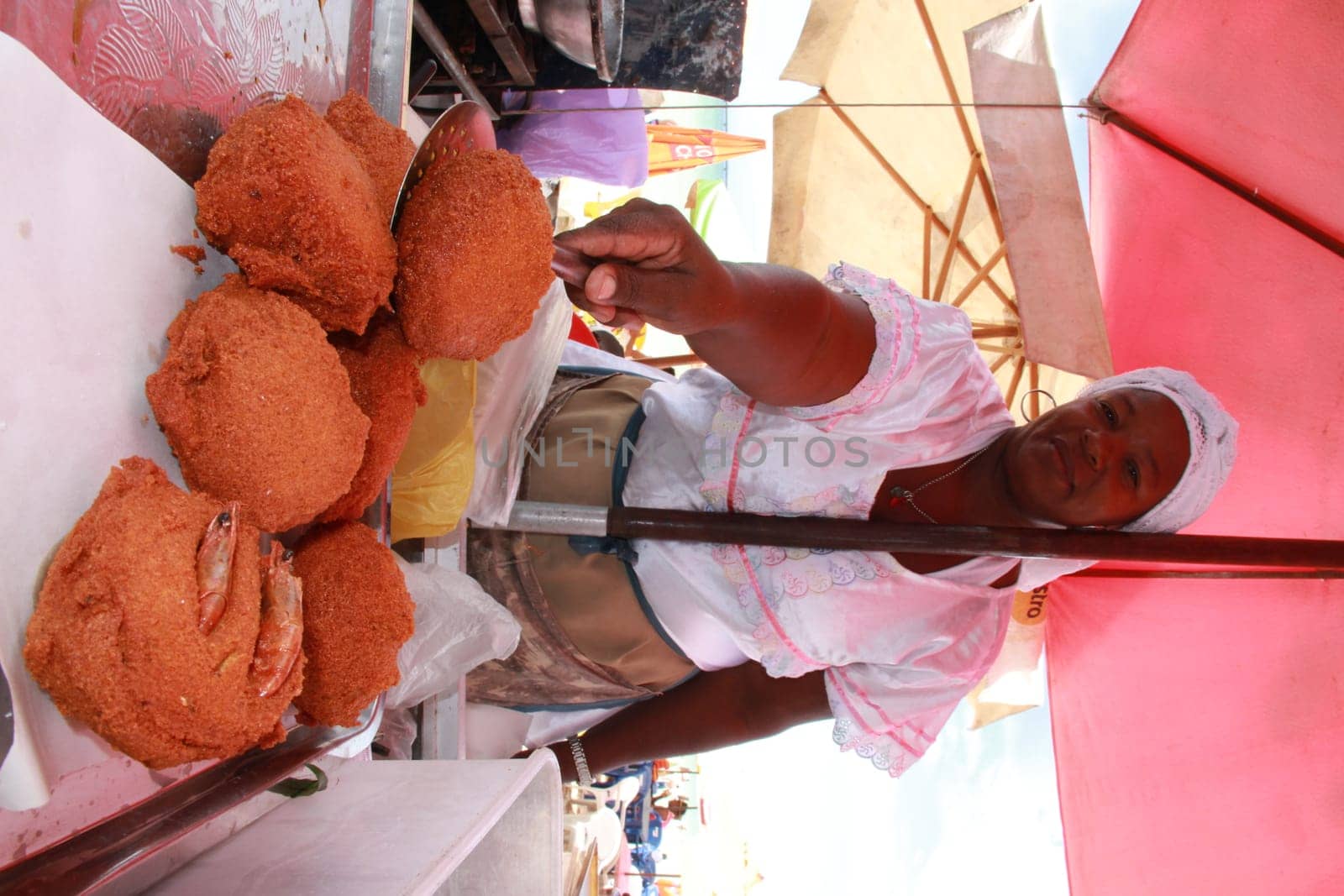 salvador, bahia / brazil - october 7, 2012: baiana de acaraje prepares food at a stall in downtown Salvador..