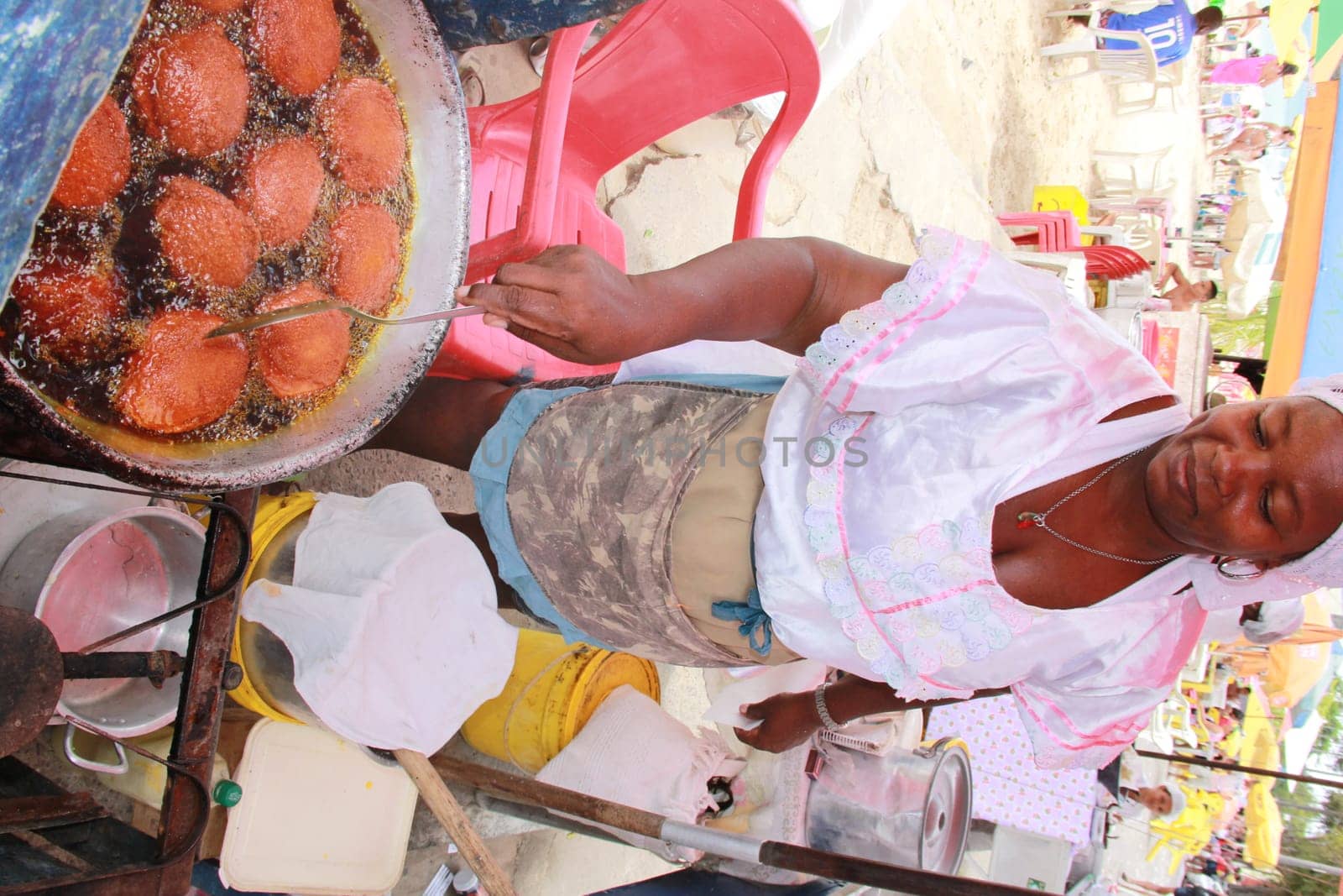 salvador, bahia / brazil - october 7, 2012: baiana de acaraje prepares food at a stall in downtown Salvador..