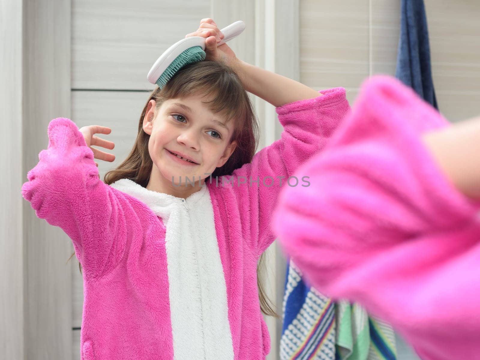 Girl combing her hair in the bathroom early in the morning