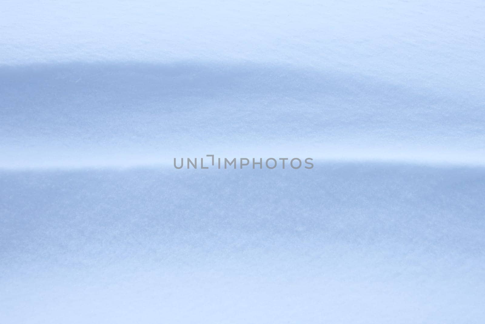 Soft snow hills surface. Snowy mound texture. Winter snowdrift landscape background.