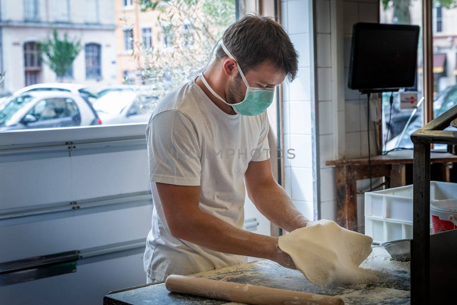 Man is working in a pizza restaurant drive with his mask and covid 19 protection. Pandemic situation