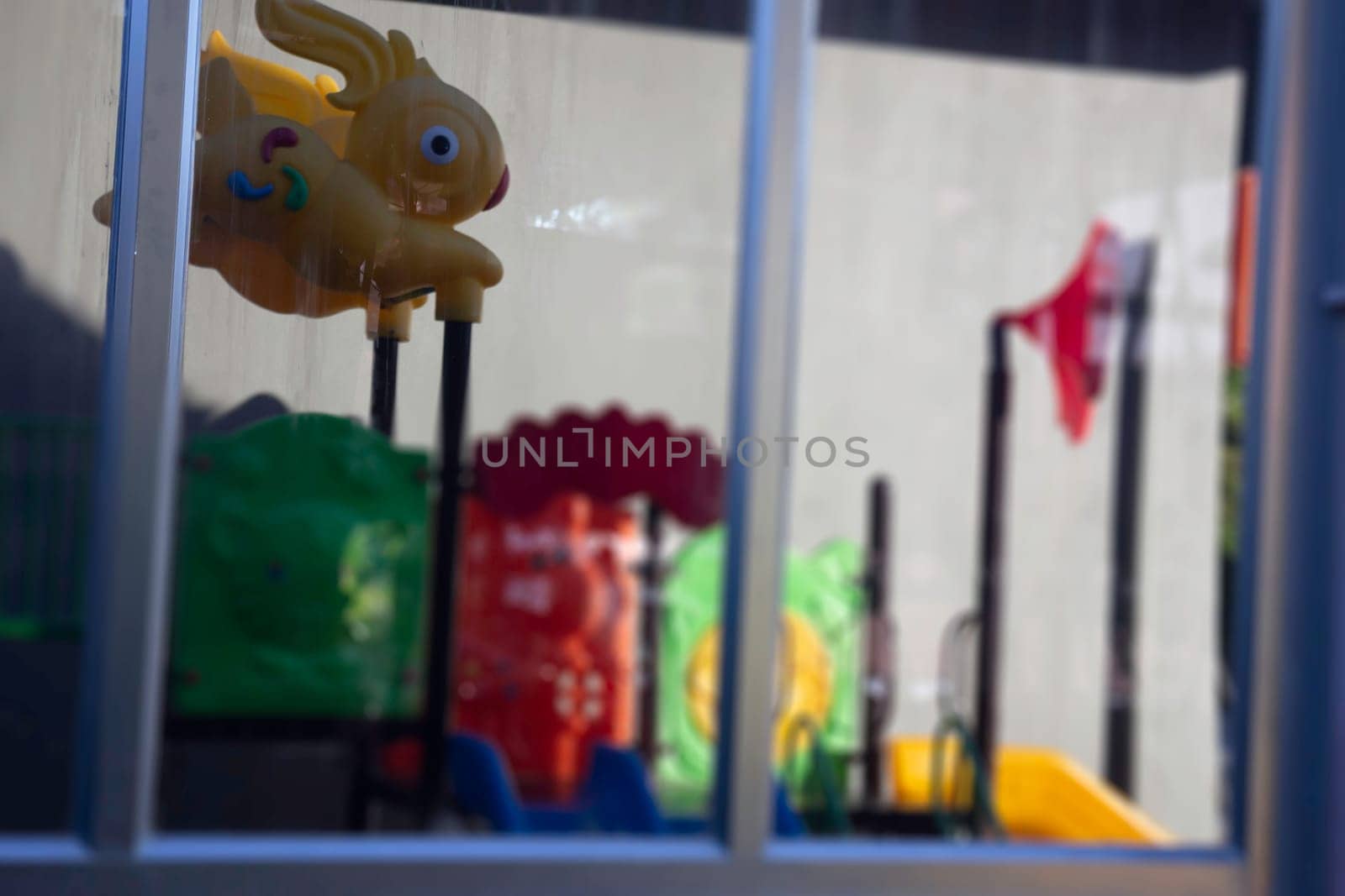 Children playground reflection on window glass, stock photo