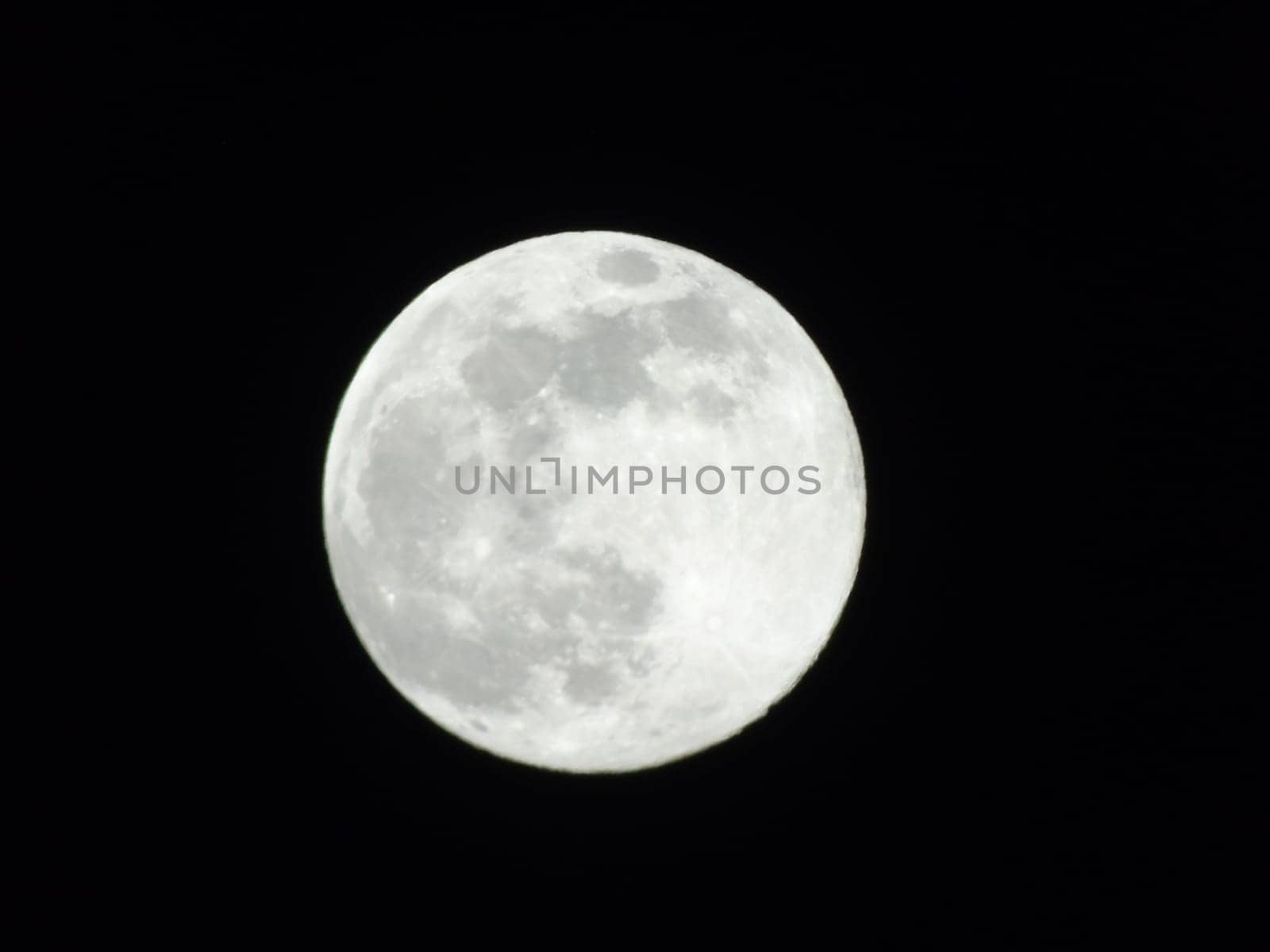 An amazing photography of the full moon over the city of Genova by night with a great clear sky in background and some stars