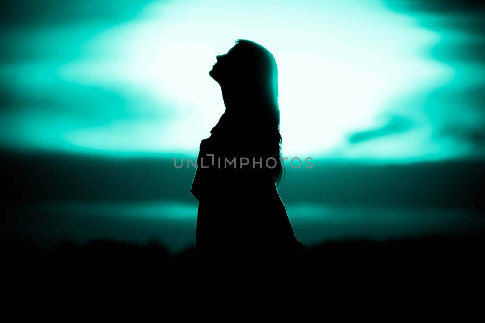 Silhouette in front of sunset or sunrise in summer nature. Symbol for healing burnout therapy, wellness relaxation or resurrection.