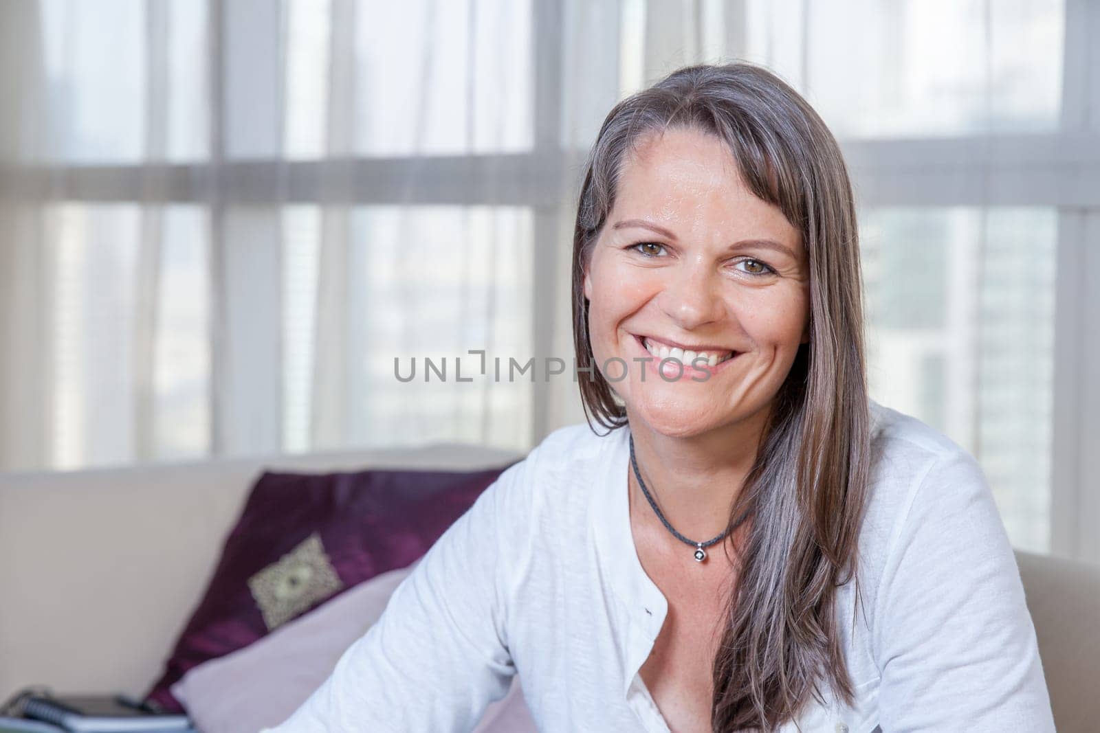 Happy smiling mature woman in her urban apartment