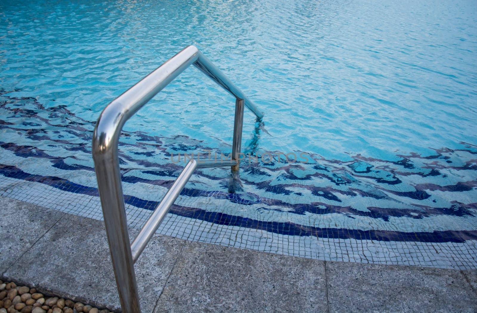 blue swimming pool with teak wood flooring stripes summer vacation
