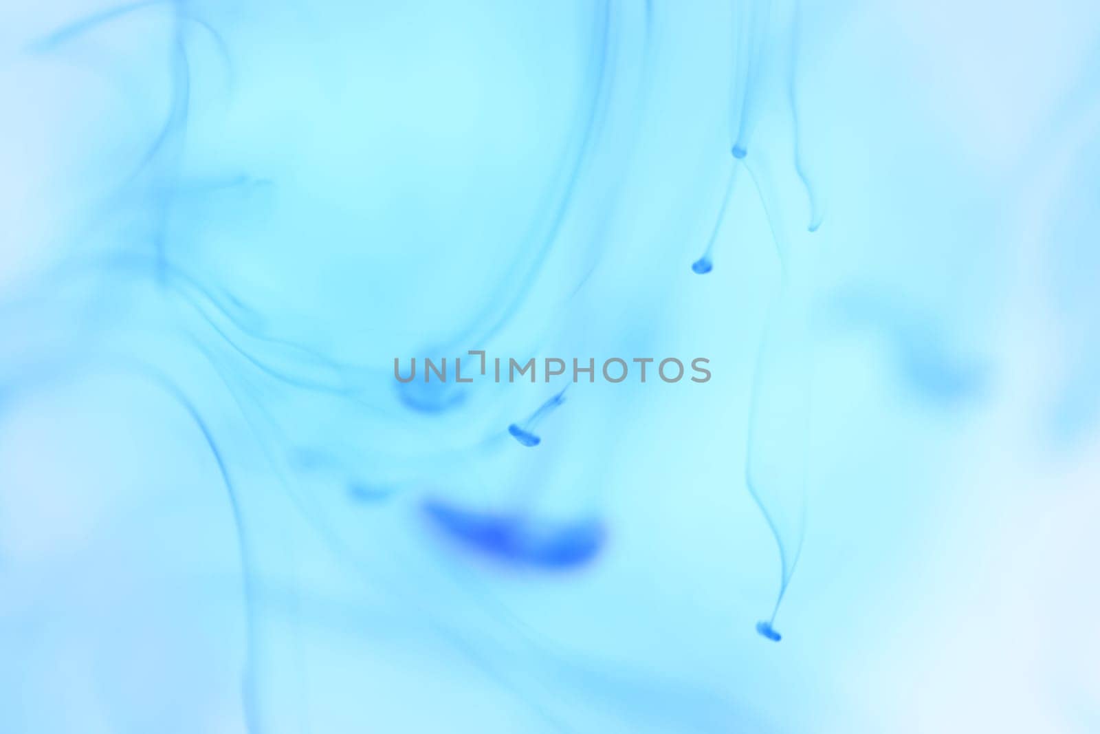 Blue Ink Drips in Clear Water. Soft Ambient Background.