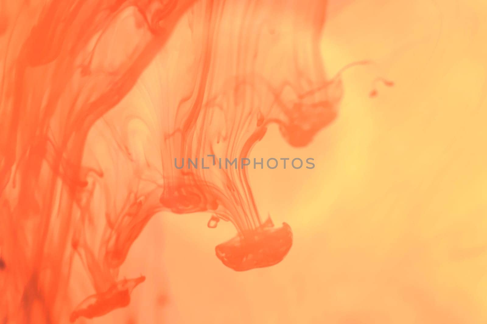 Orange Ink Drops in Water. Liquid Fantasy Art Splashes. Abstract Background.