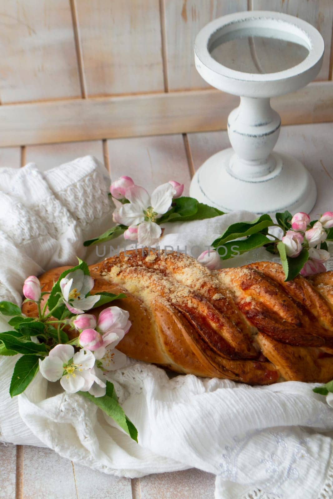 Tasty braided buns on lacy napkin and shabby table