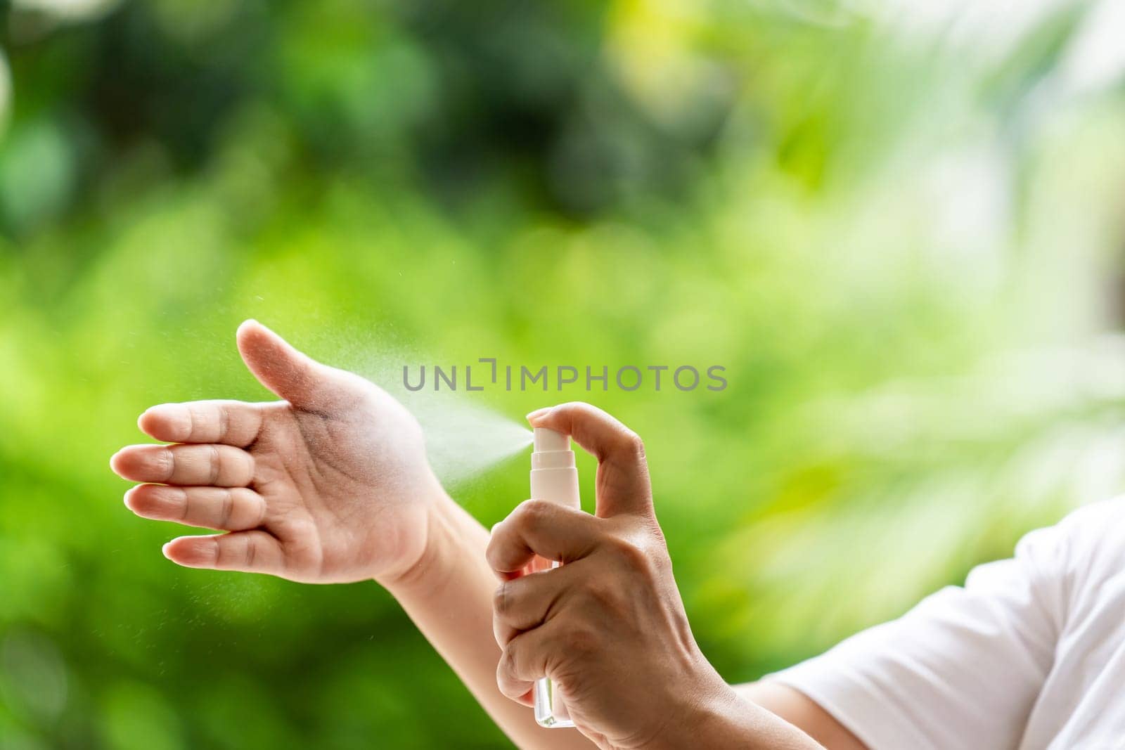 close-up cleaning hand using alocohol spray Hand sanitazer from bottle spraying, disinfection for safety prevent and protect from infection of virus and germ Covid-19 coronavirus world pandemic.