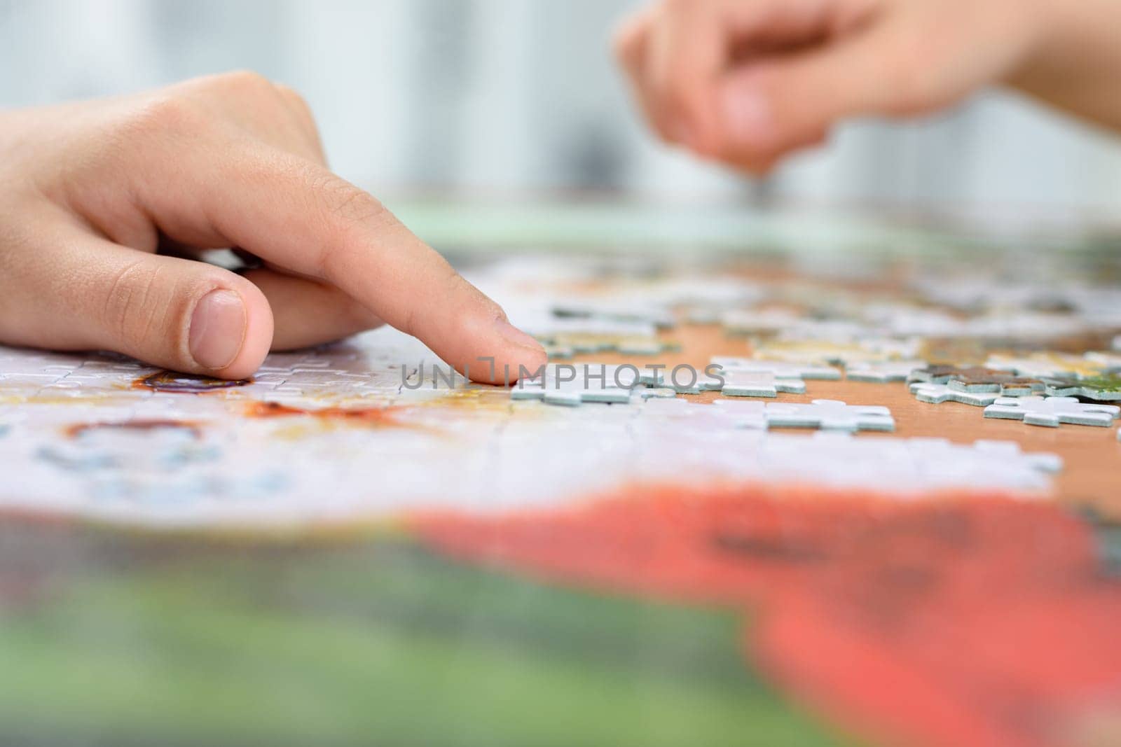 Close-up of children's hands collecting jigsaw puzzles