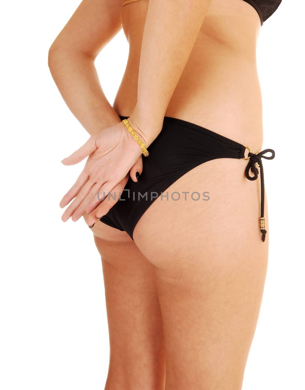 The bottom of a young woman standing from the back in a black bikini.with her hands on her butt, isolated for white background.