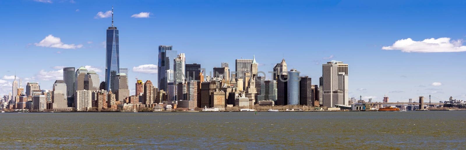 Panorama of Lower Manhattan of New York City with USA Flag from liberty island. This also known as Downtown Manhattan or Downtown New York the largest business district in state of New York and USA.