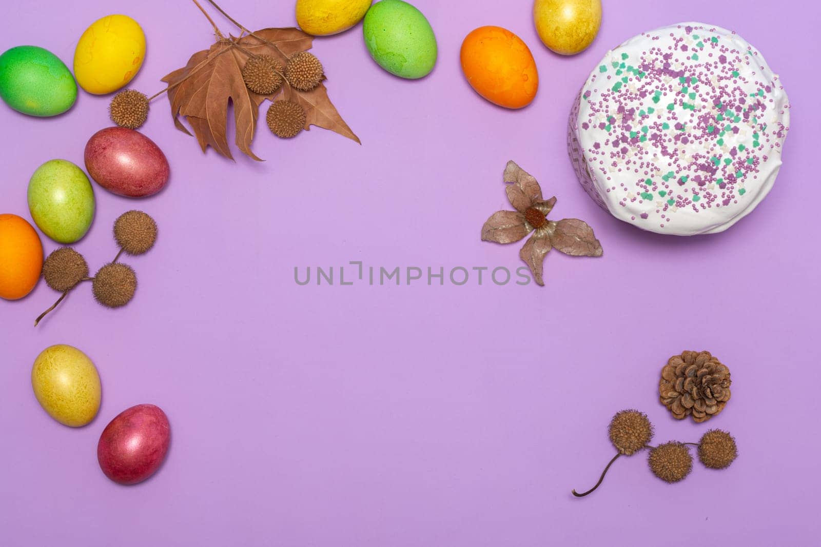 location of Easter cake and painted eggs on a lilac background