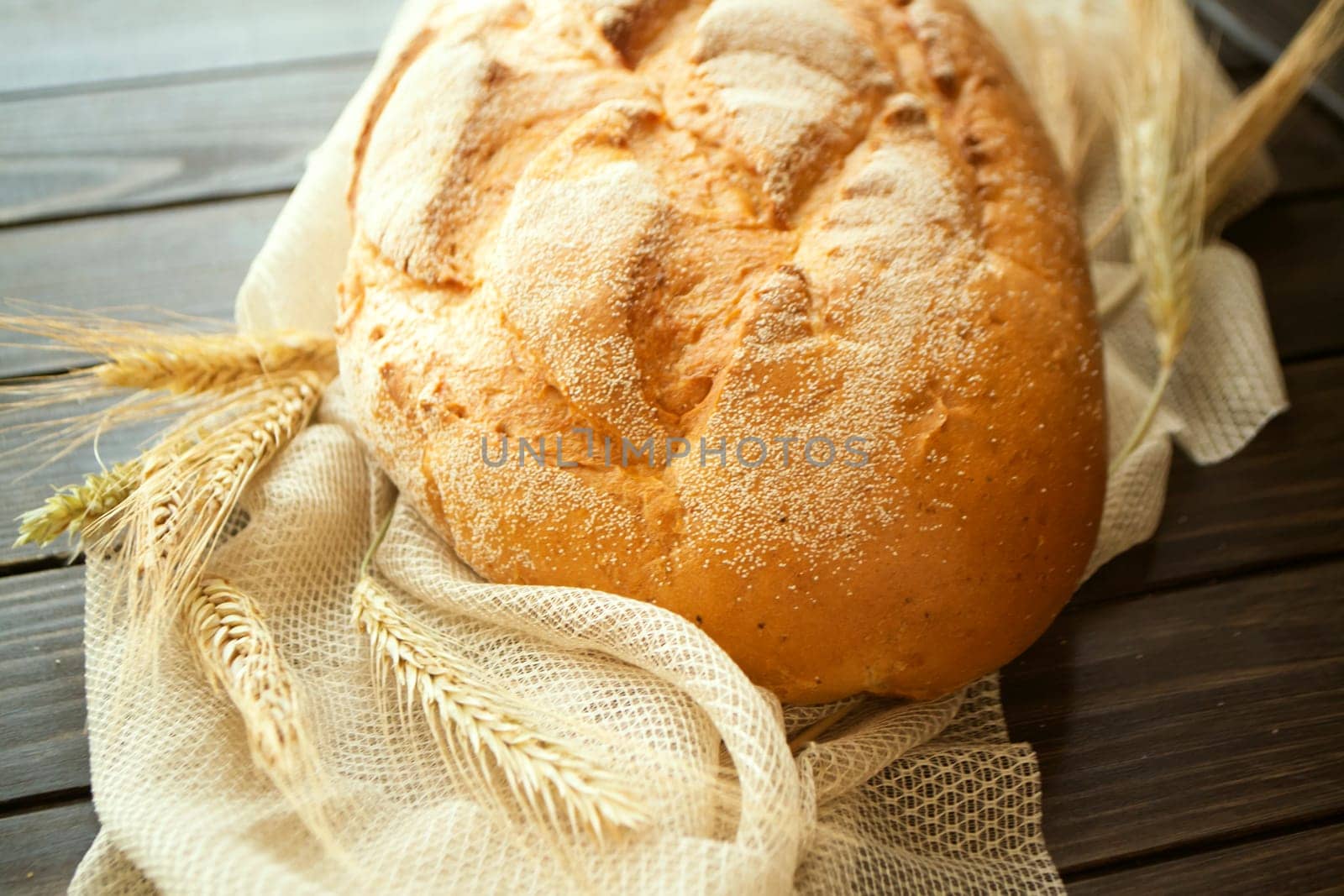golden rustic crusty loaves of bread on black rustic table