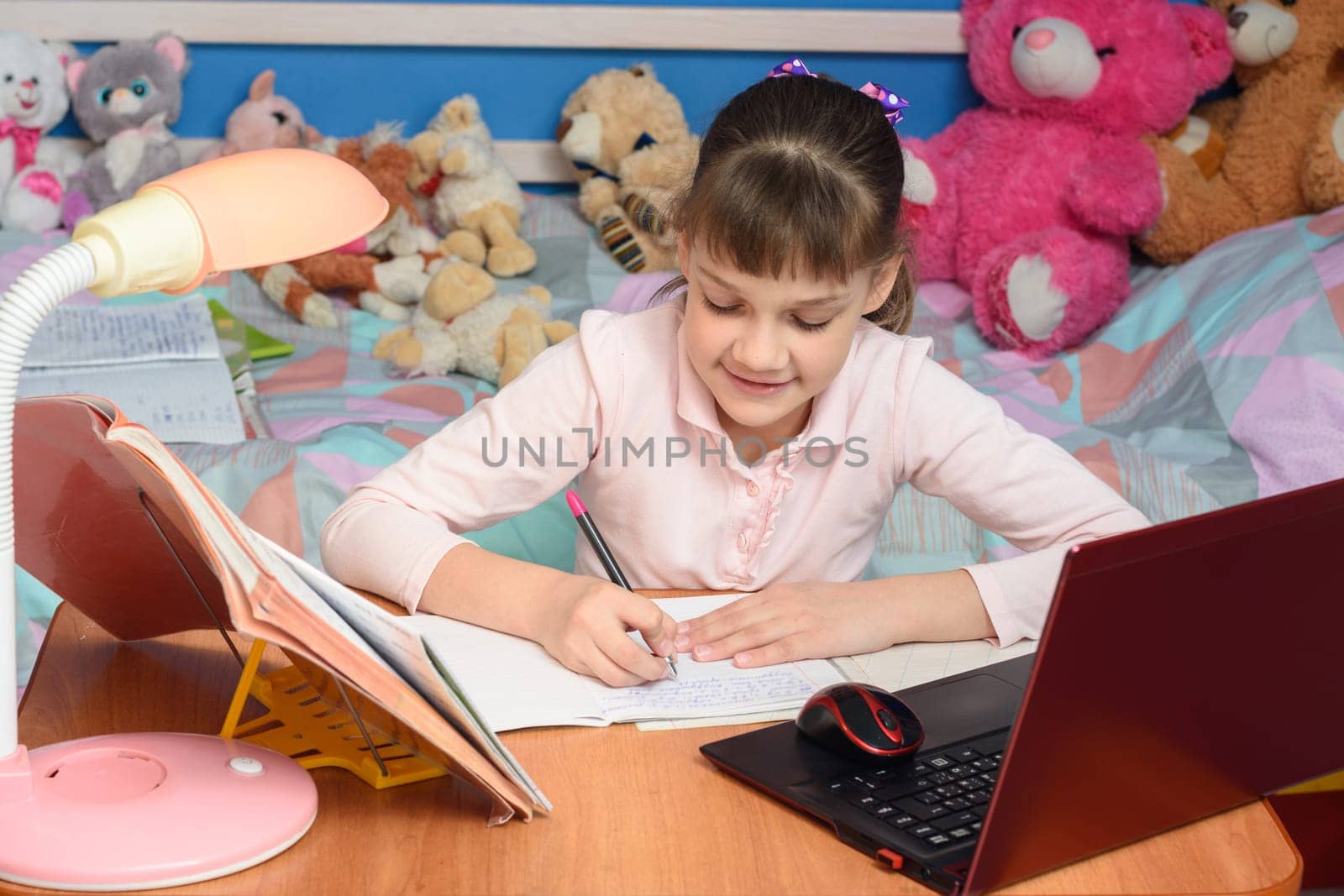 in the children's room sits a girl at a desk and makes a homemade