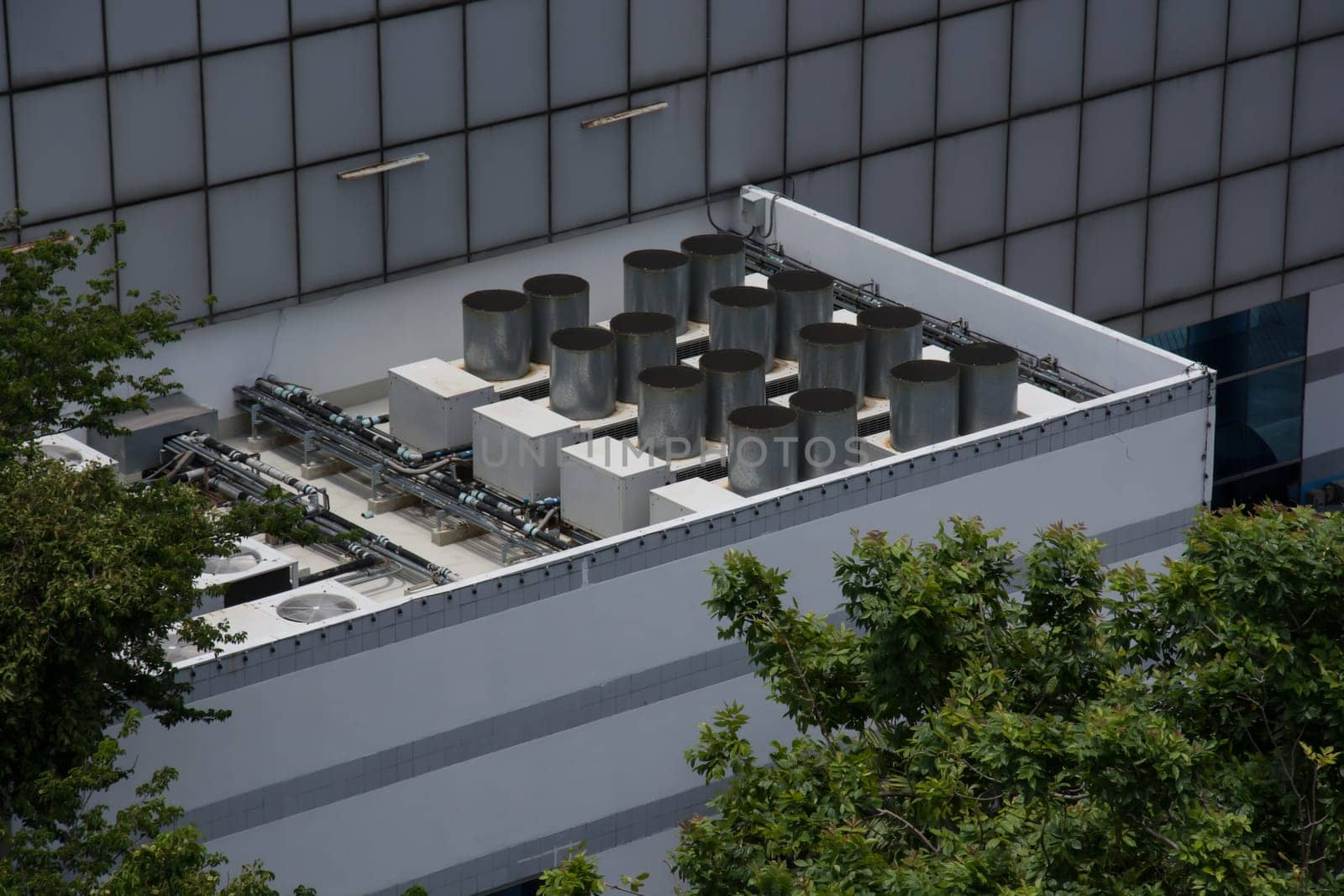 Commercial cooling HVAC air conditioner condenser on large commercial building rooftop for climate control and refrigeration temperature AC conditioning system