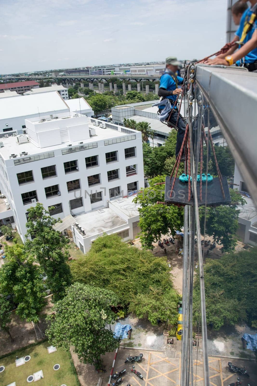 workers cleaning windows service on high rise building
