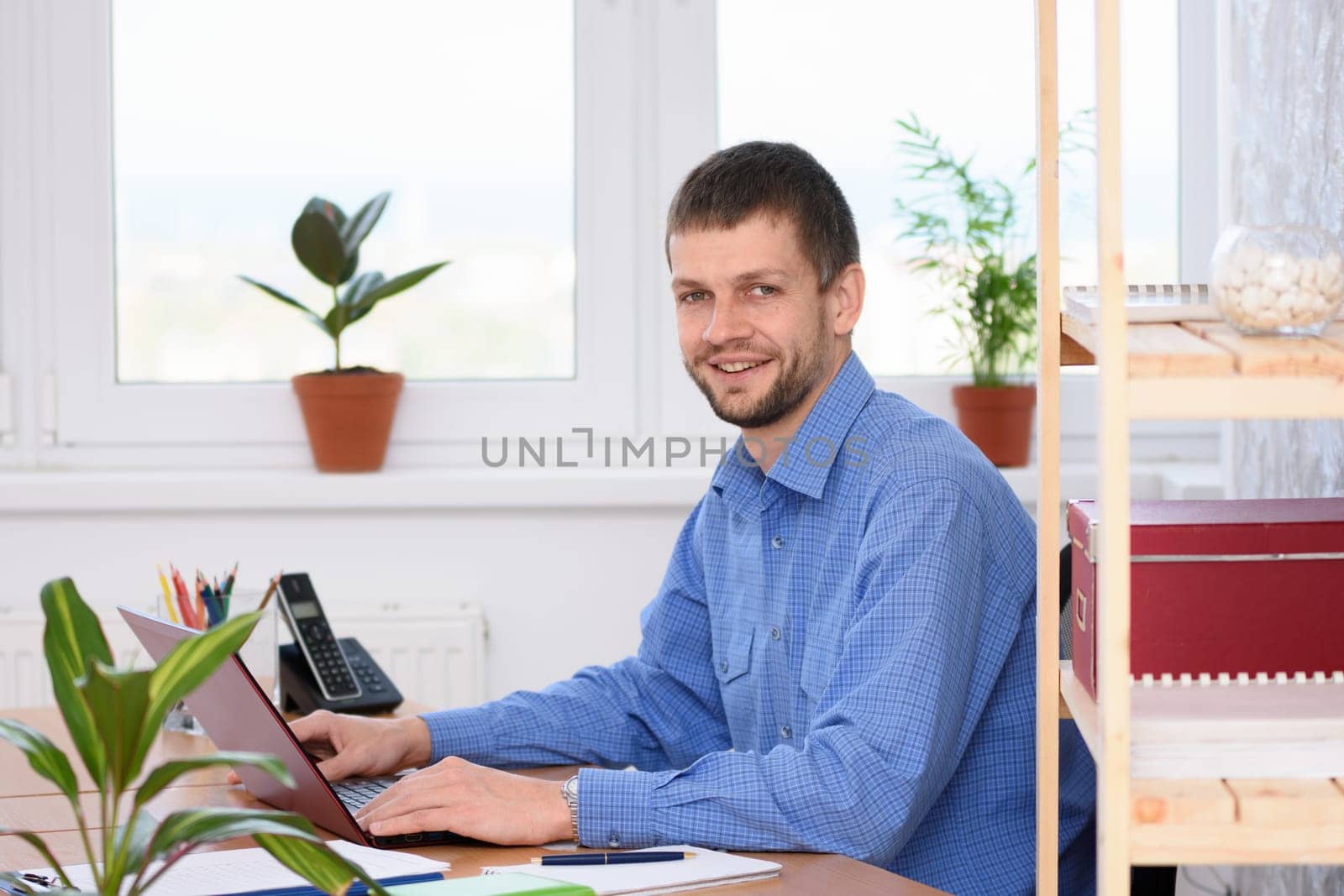 Business man works at the computer and looked into the frame