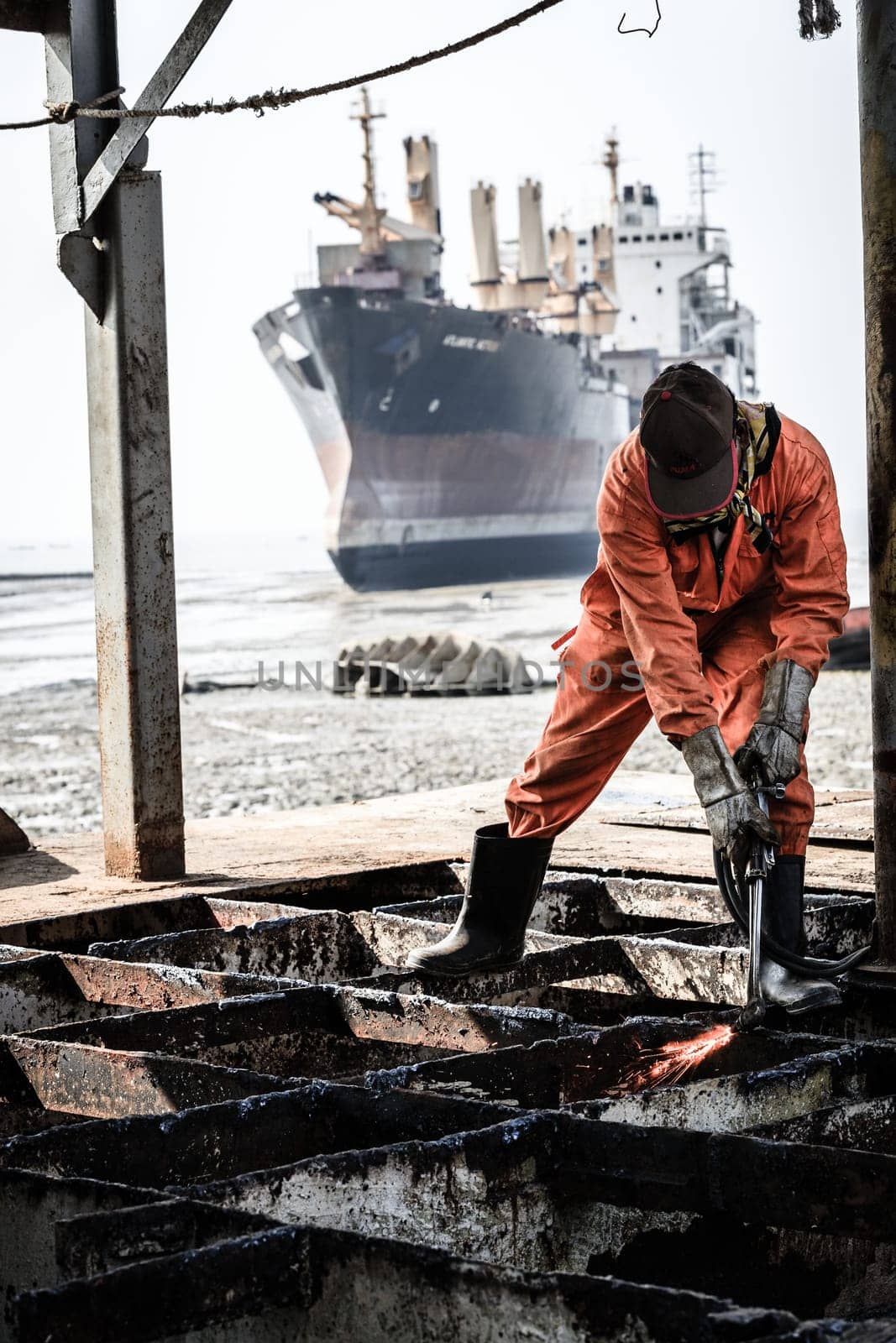 Chittagong, Bangladesh, December 23, 2017: A worker is cutting through metal deck structure of a ship at a ship-breaking yard in Chittagong, Bangladesh