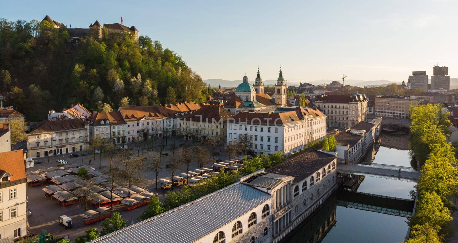 Aerial drone panoramic view of Ljubljana medieval city center, capital of Slovenia in warm afternoon sun. Empty streets during corona virus pandemic social distancing measures.