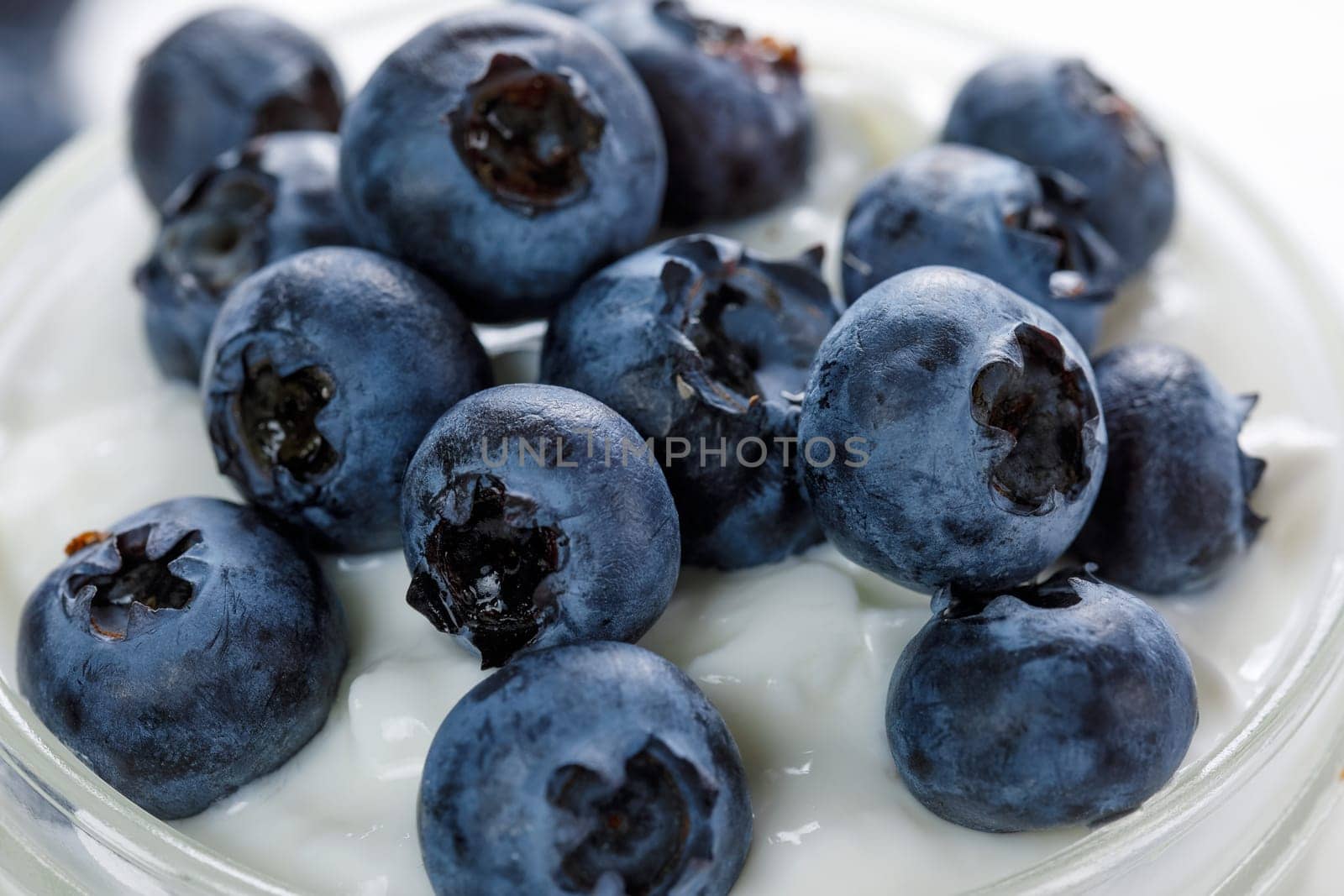 Ripe blueberries decorate yogurt, close up, healthy breakfast