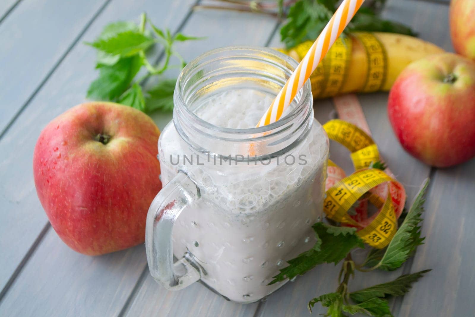 Organic smoothie of nettle, apple and banana in jar. Healthy lifestyle concept. Tape mesure
