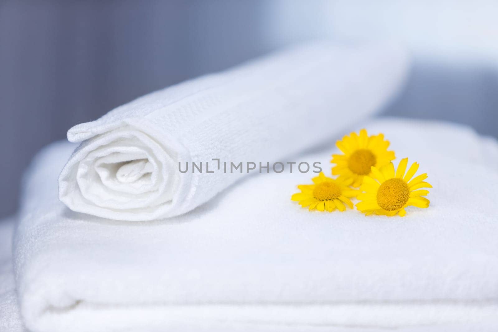 Three yellow flowers on folded towels and backlight
