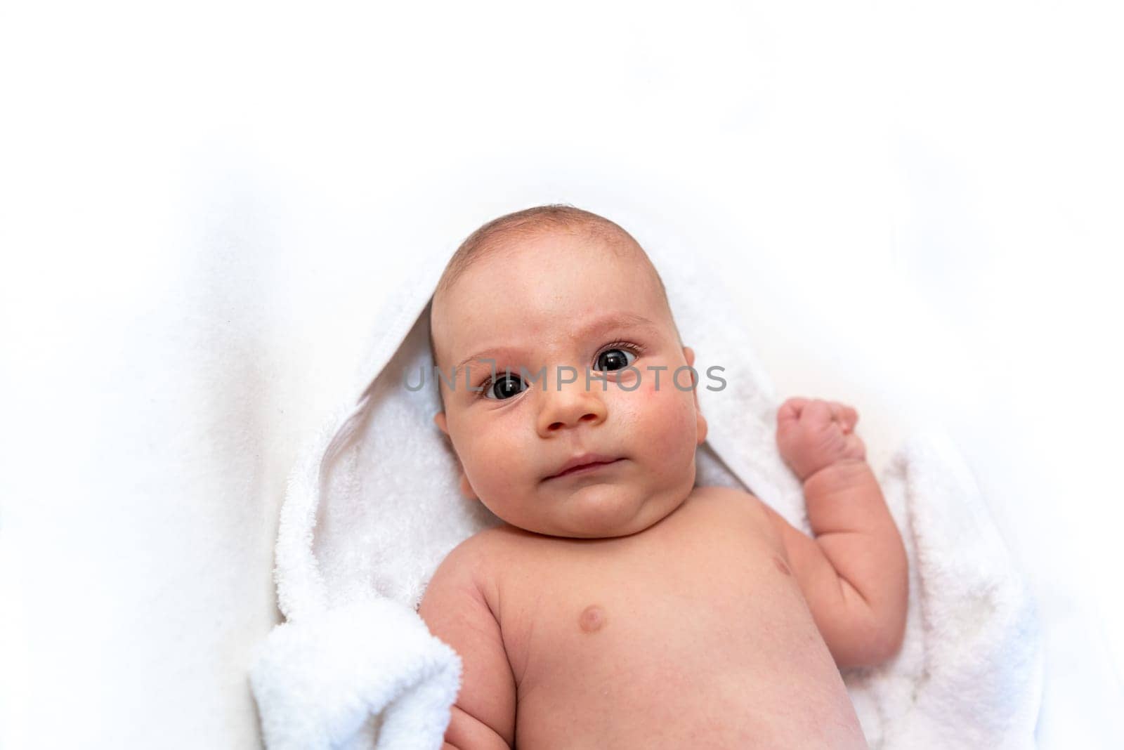 Adorable 2 months old little baby boy on towel after bath over white background