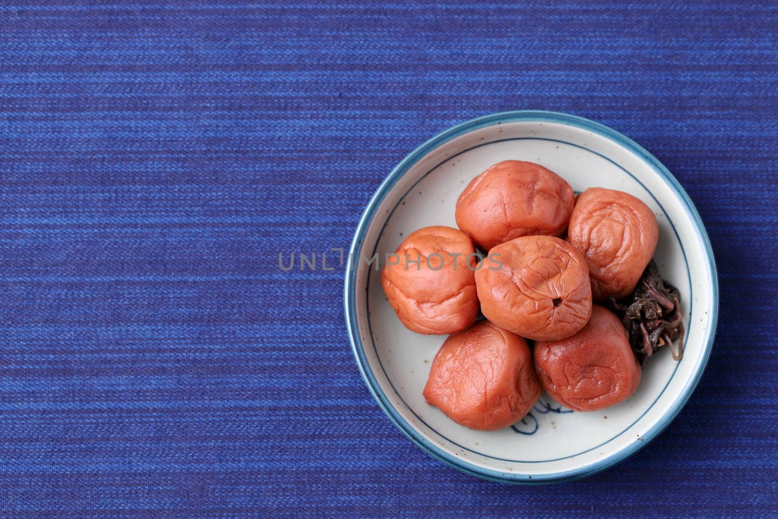 Japanese food, pickled Umeboshi in a dish on table, top view