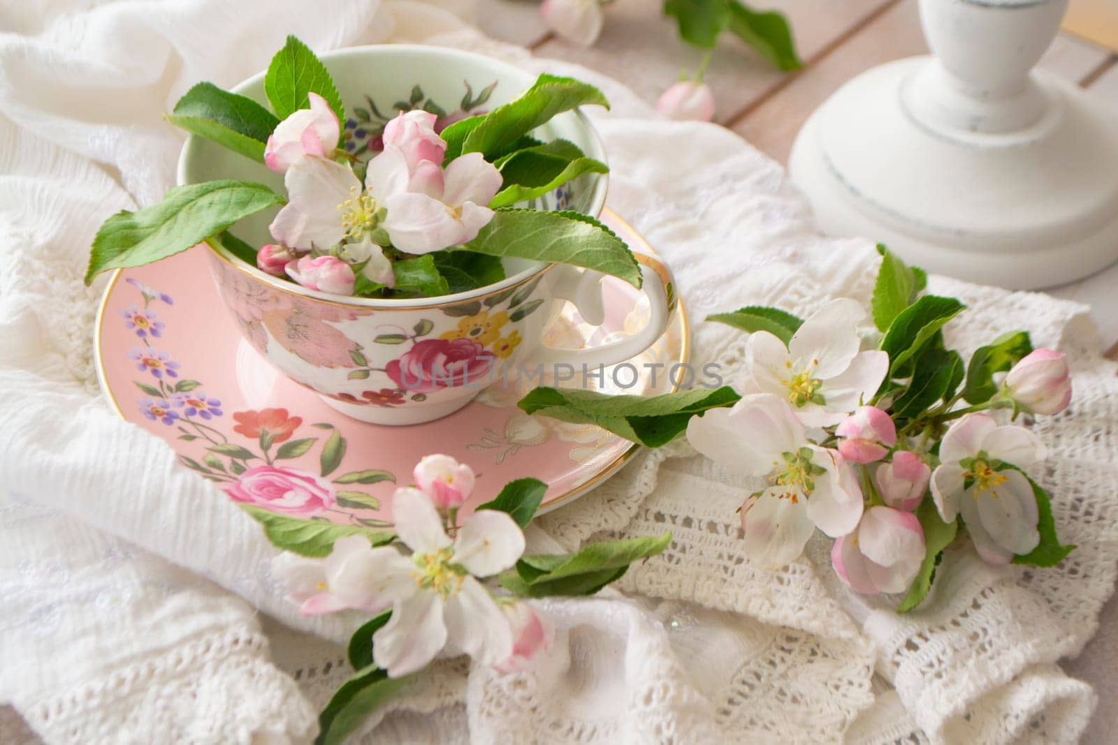 handmade lace on shabby chic and pink retro mug with white flowers. Macrame closeup. Wedding or holiday background.