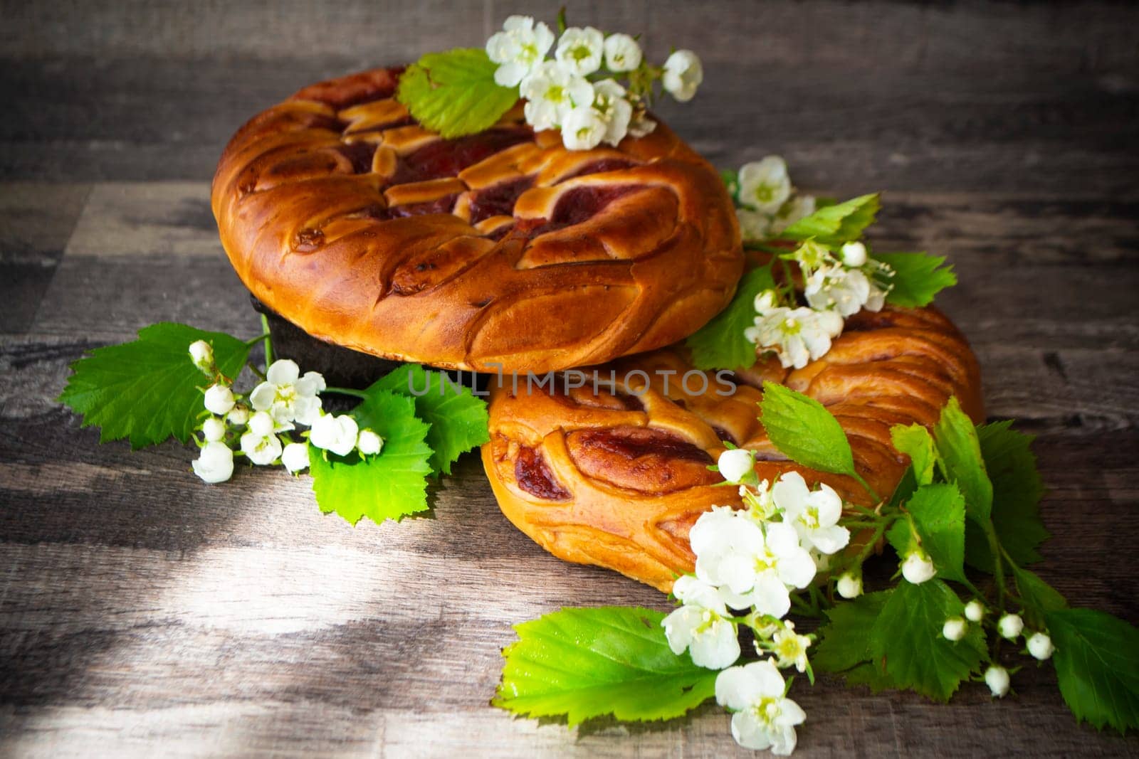 whole strawberry jam tart decorated with white spring flowers