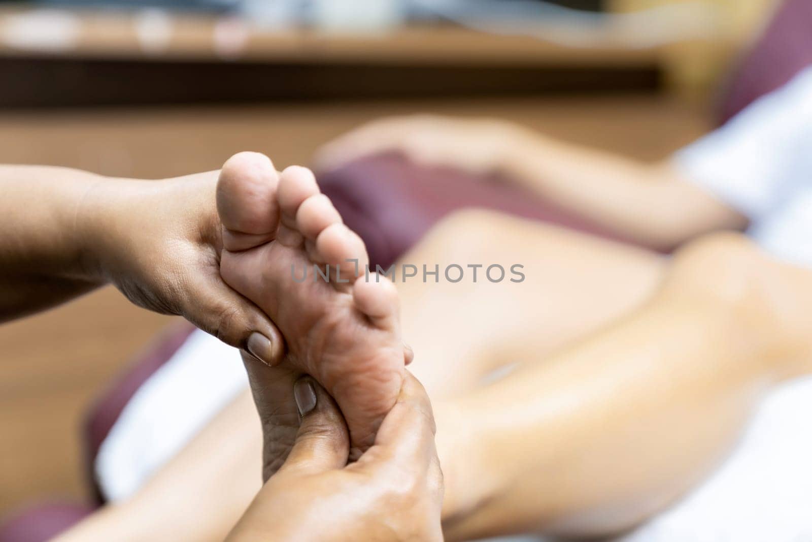Quarantine asian woman do foot massage at home while city lockdown for social distance due to coronavirus pandemic. Massage and spa is one of service business that shutdown while city lockdown.