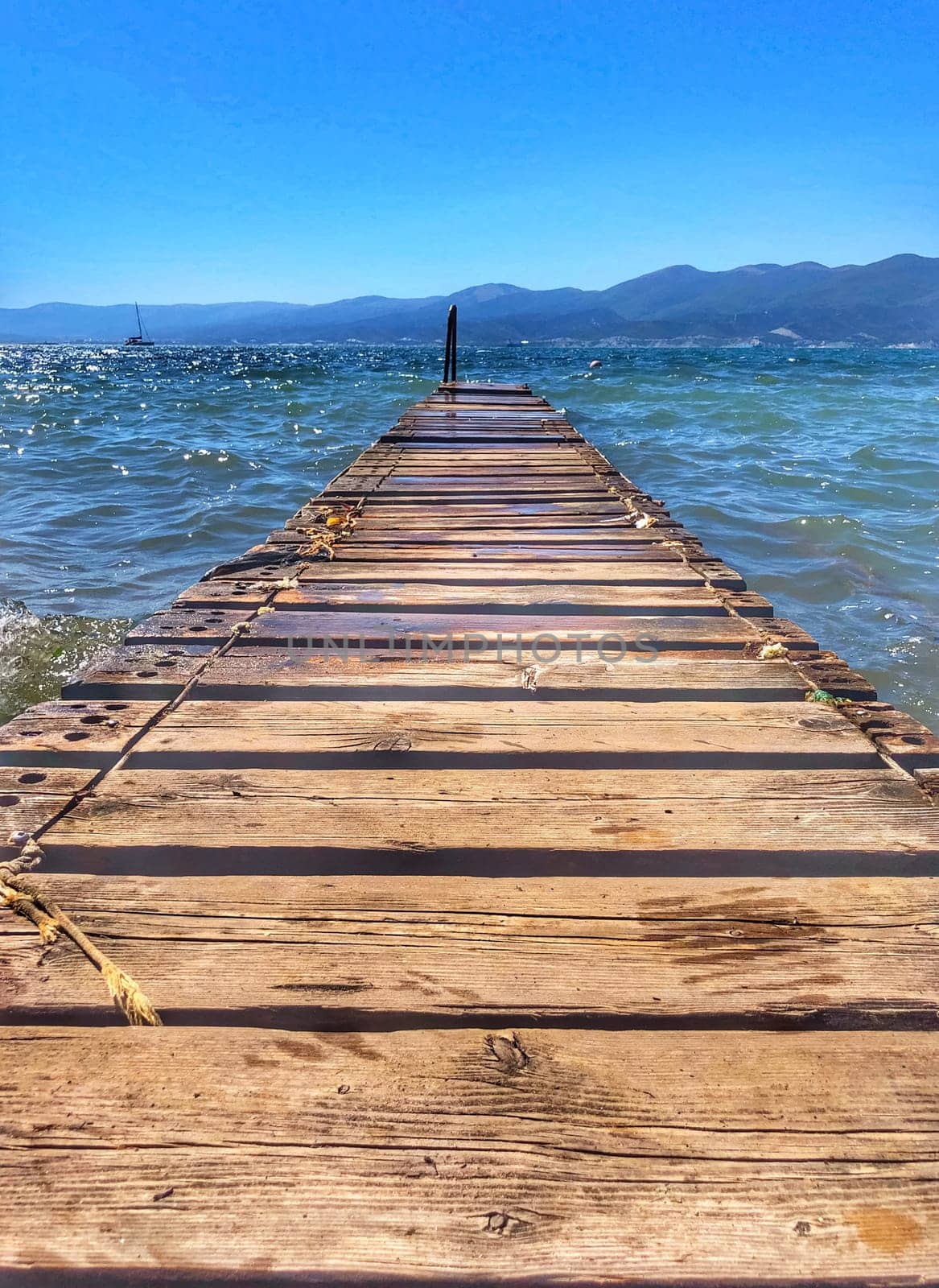Wooden pier by the sea. Boards of the pier and sea waves.