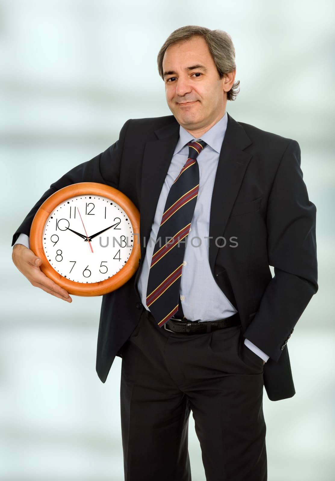 mature handsome business man holding a clock