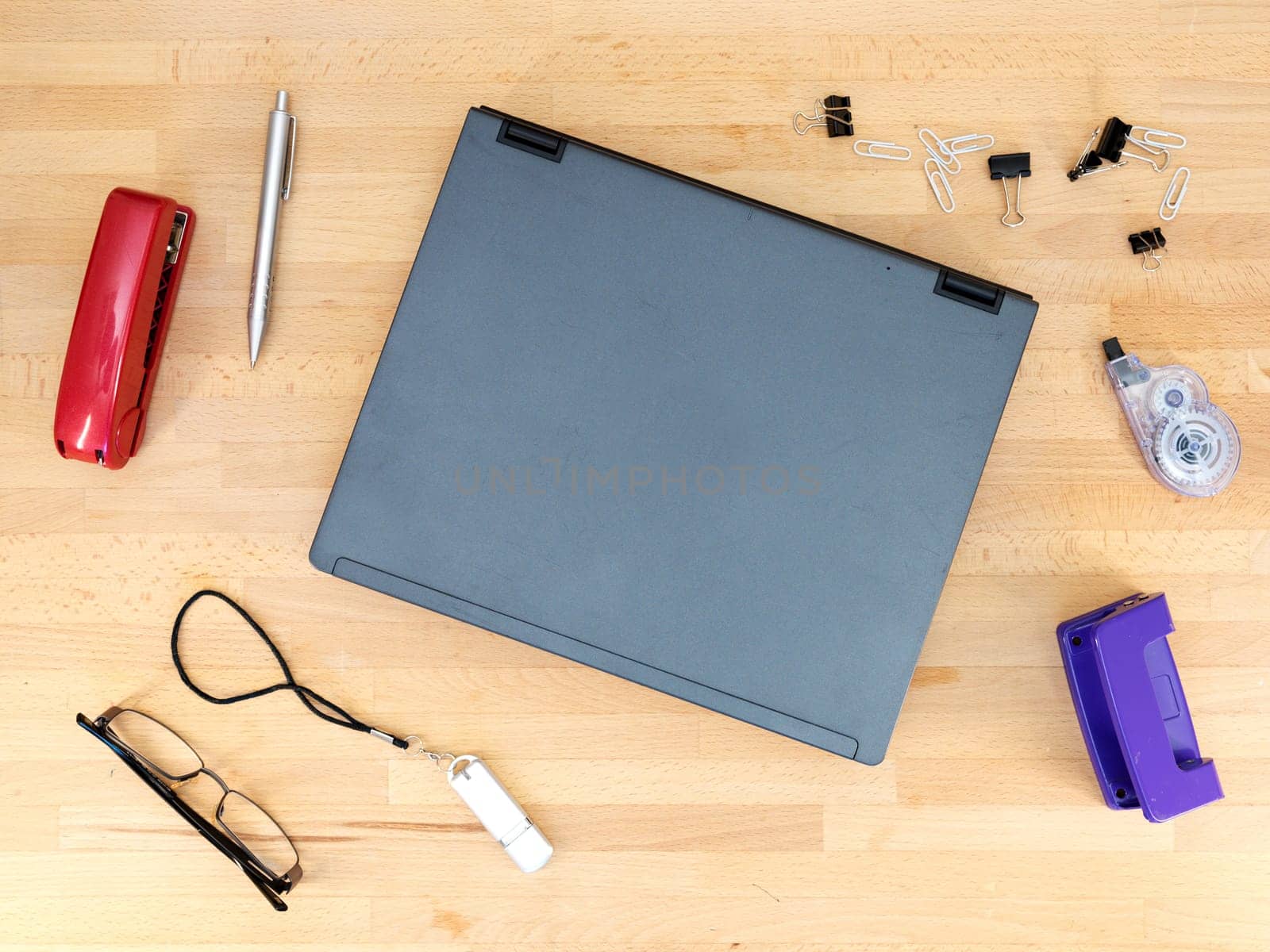 Stationery and work objects on a wooden  office desk