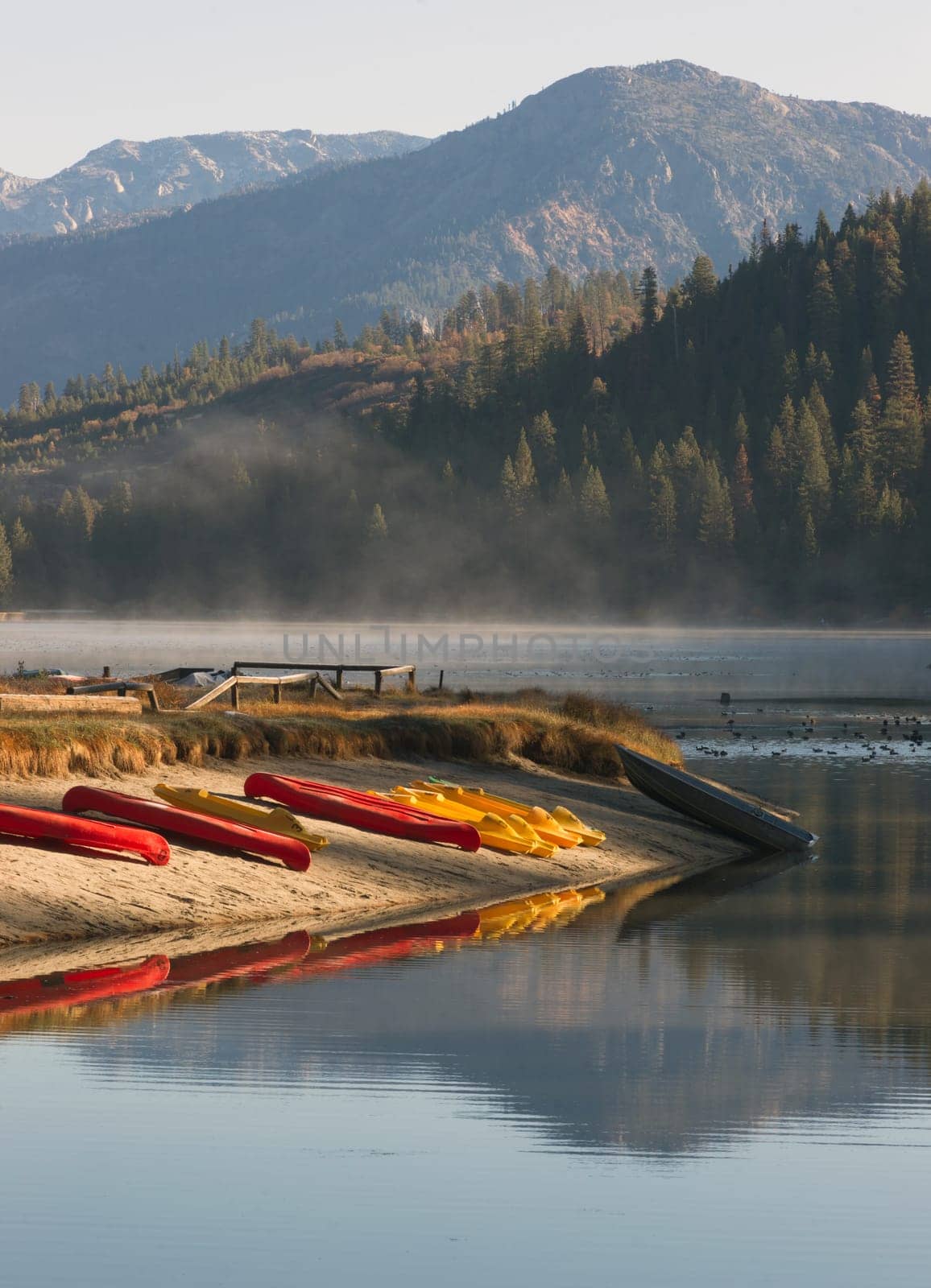 The early morning mist has yet to burn of the lakes surface of this mountain lake
