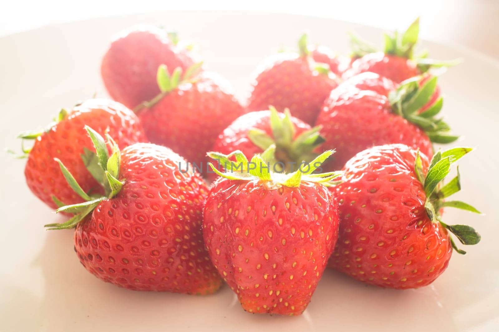 Fresh ripe strawberries on white plate, stock photo
