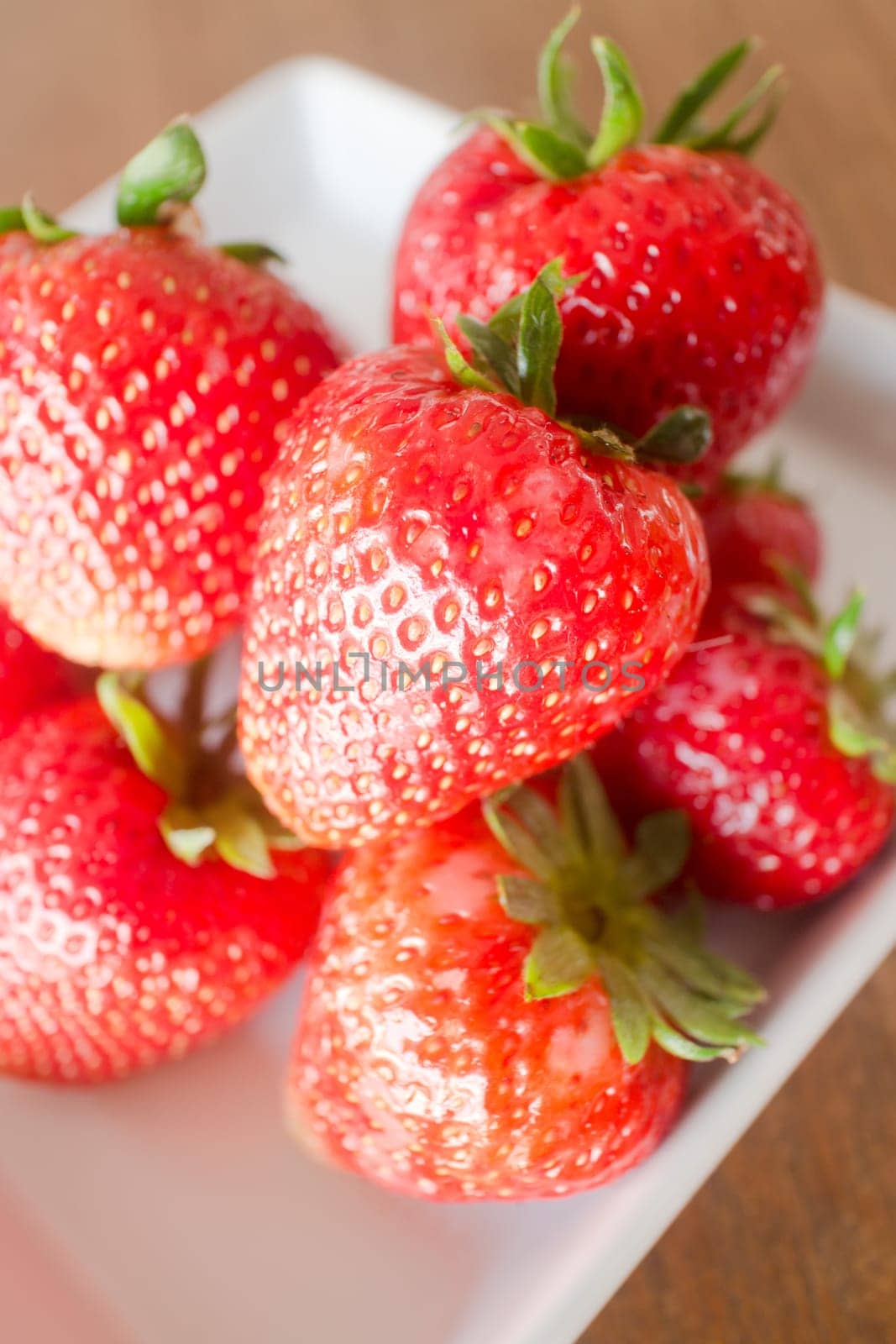 Fresh ripe strawberries on white plate, stock photo