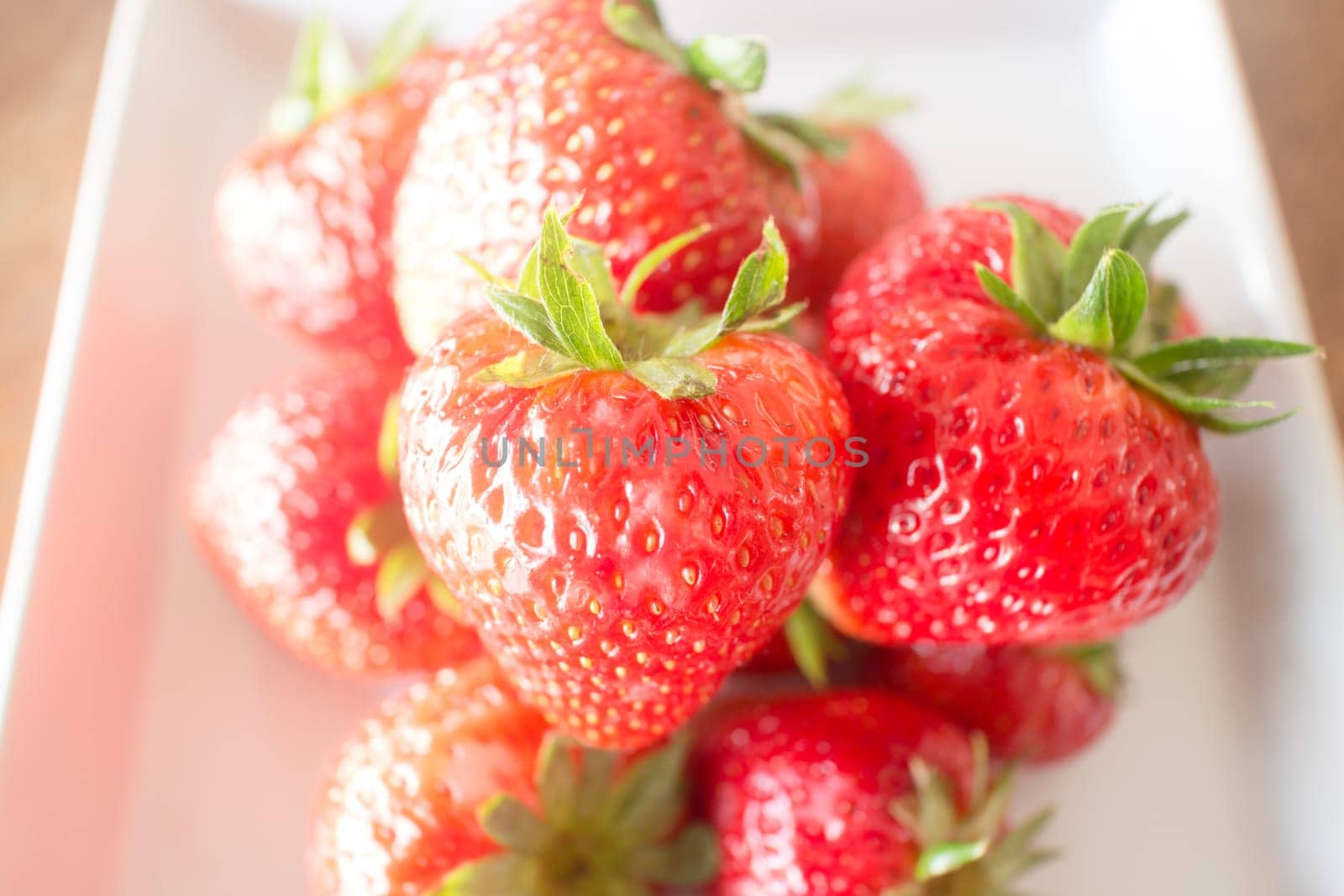 Fresh ripe strawberries on white plate, stock photo