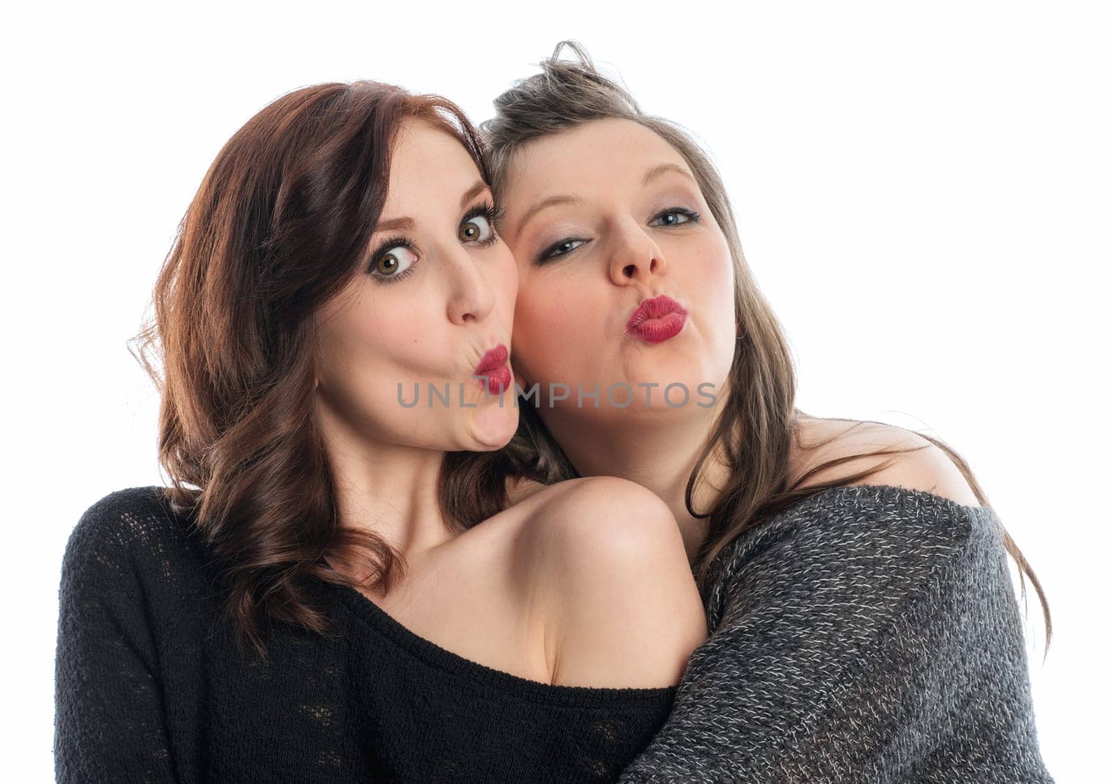 Two girlfriends hug each other and make kiss mouth