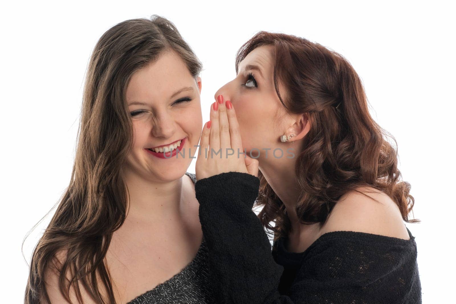 Girl whispers something in her friend's ear