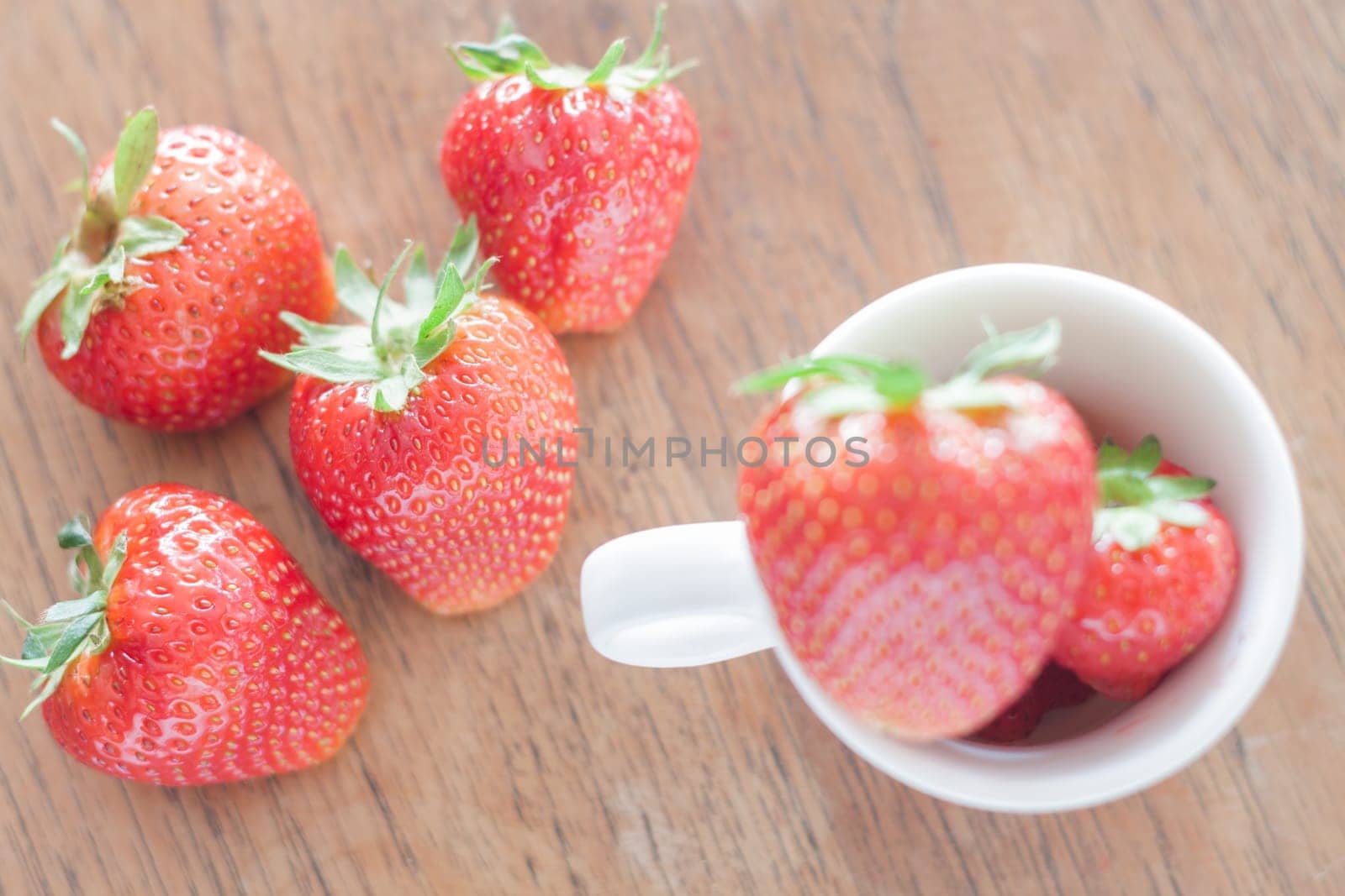 Fresh strawberries on wooden table, stock photo