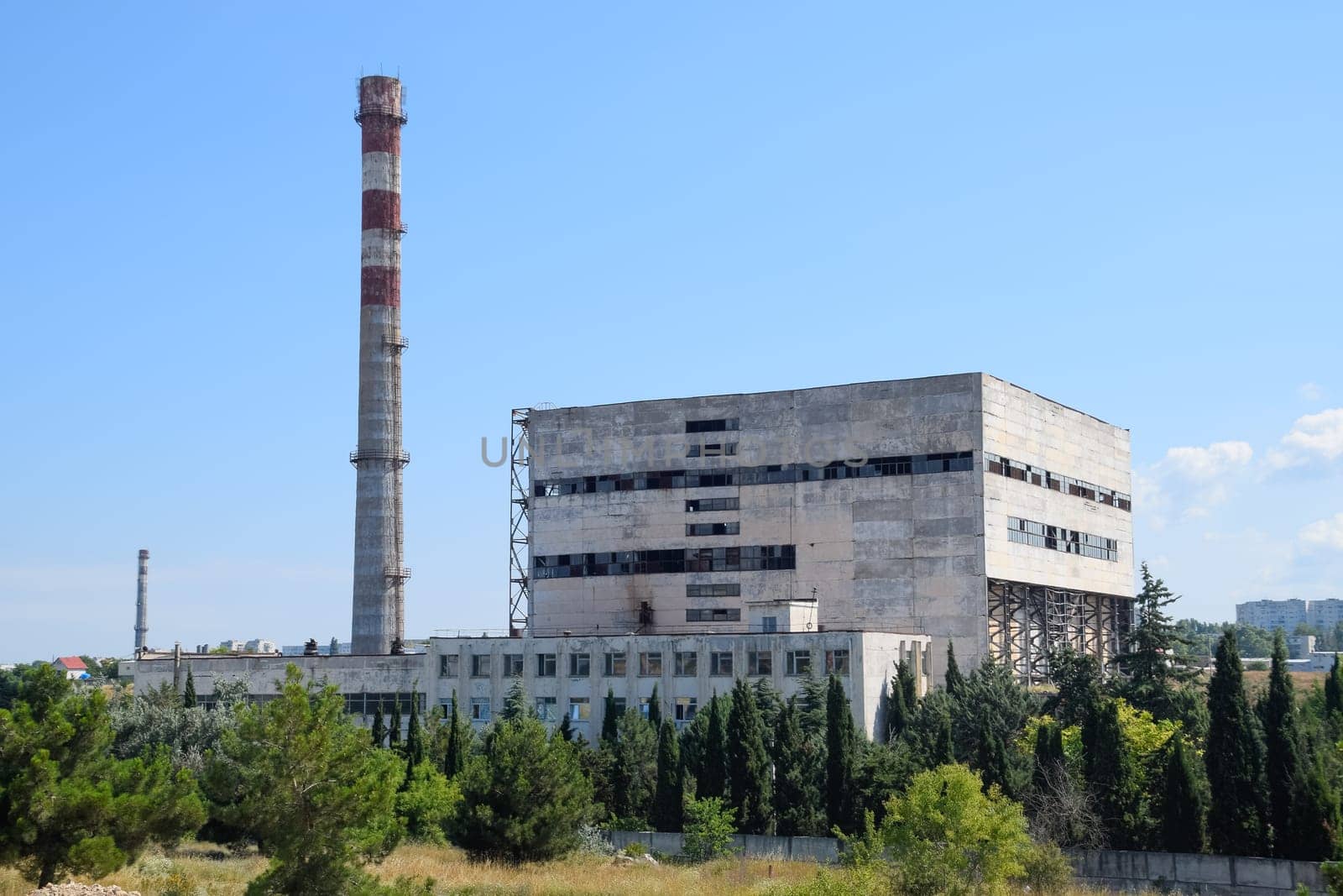 An old Soviet factory with a pipe. Abandoned Soviet industry.