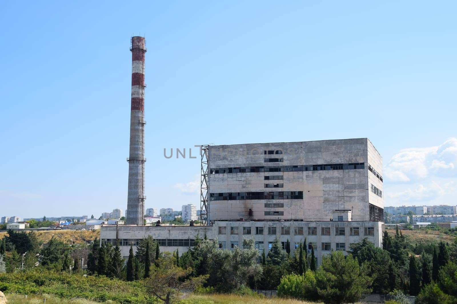 An old Soviet factory with a pipe. Abandoned Soviet industry.
