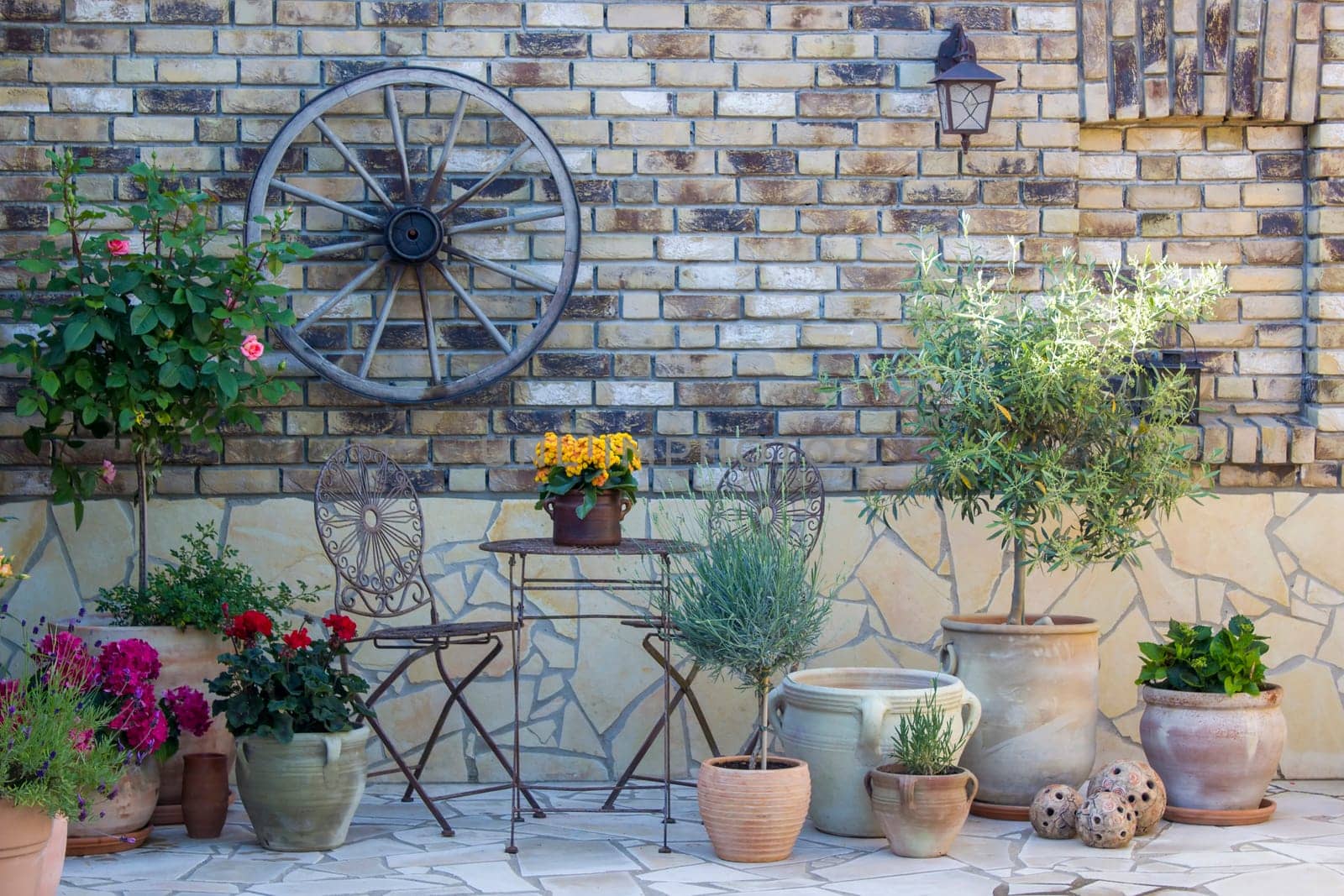 beautiful place in the garden in the mediterranean style, brick wall with grill and pots with flowers