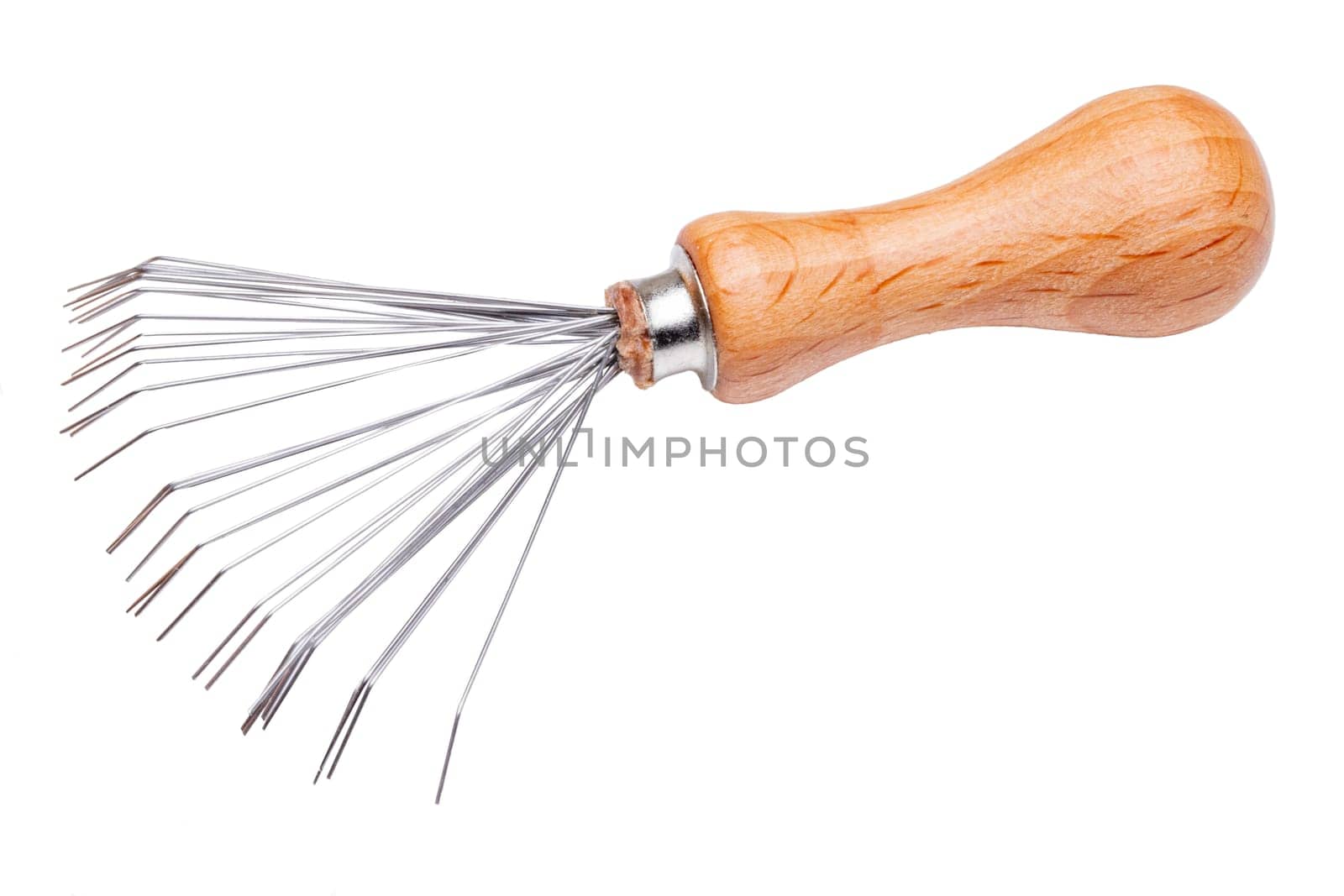 Closeup of a brush and comb cleaner with wooden handle and metal brushes. A very practical tool for removing hairs that have got stuck in the hairbrush or comb. Macro.