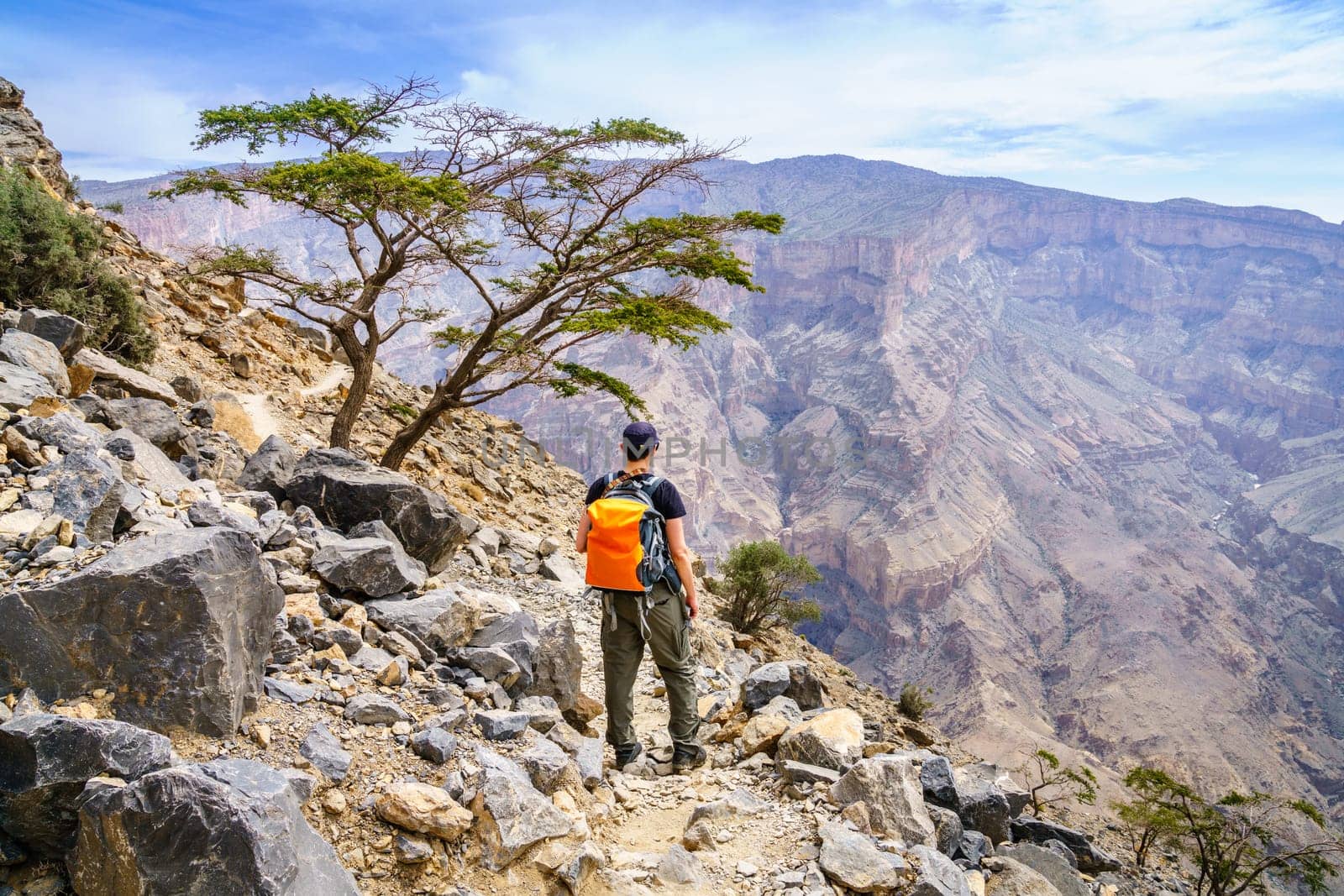 A hiker is enjoying the view of the canyon in Jebel Shams Mountain in Oman