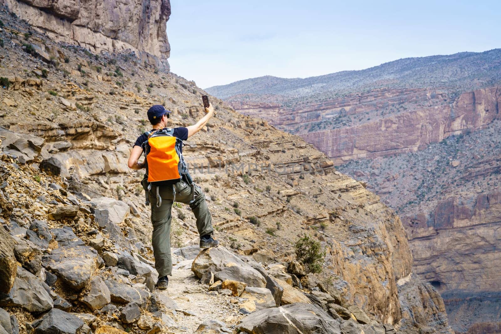 A hiker is taking selfie in Jebel Shams, Oman